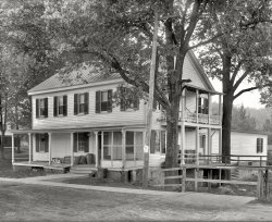 Fairfax County, Virginia, circa 1926. "Freeman House Store -- Vienna, Va." A historic structure that figured in the Civil War. Our title comes from a retail detail. National Photo Company Collection glass negative. View full size.
Shopping info needed !This is certainly a "genteel" operation, minus the many advertising signs usually posted on the front façade. How will I know the kinds of tobacco, bread, soft drinks, or pickles which are available?
3 ply paperThere used to be a building paper that was made with a very heavy outer layer, treated with some kind of resin, the middle with a tarry substance (also something like jute fibers) and the inside paper tough but not as heavy as the outer layer. This stuff was good for several years exposed to the weather. Looks like someone has ordered rolls, and the storekeeper has kept them on the porch for easy pickup.
Is that tarpaper?Next to the Corby Bread boxes?
Slick and quickSpotless Cleanser sign on the right.
Here she is!View Larger Map
Fetch my julepThat hammock on the second floor porch... speaks volumes about the pace of Southern life. I'm there.
The Easy WayHere's part of Spotless Cleanser's marketing budget, all starting with just a nickel.
Bigger Than A BreadboxThe Corby Bread lock-box on the porch, where the bakery leaves the bread before the store opens. Not uncommon today, but they usually hold specimens collected from patients in a medical practice, to be picked up by a laboratory for processing. What I can't identify are the tubes stacked up to the left of the breadbox.
[Paper towels, or maybe toilet paper or butcher paper. I see the word PLY on the end. - Dave]
How about wrapping paper?Maybe the rolls next to the bread box are brown kraft wrapping paper, for the store's own use, since close to 100% of everything sold there went out that way, probably expertly wrapped with a cobweb of string.
FoundationBeefed up a bit, just in time from the looks of the second story balcony roof and floor! Time to drive a couple inches of wedge in to raise that beam a little more.
(The Gallery, Natl Photo, Stores & Markets)