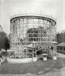 Montgomery County, Maryland, circa 1928. "Glen Echo Amusement Co." The Coaster Dips roller coaster at Glen Echo Park outside Washington, D.C. National Photo Company Collection glass negative. View full size.
Well here we are at the park


Washington Post, July 7, 1929.

Glen Echo Park, as a famous radio announcer might describe it: &#8220;Well here we are at the park, everybody. You should see the crowds, all having a good time. The music that you hear is coming from the Wurtlizer [sic] organ on the carrousel. Just listen to that roar. It's the coaster dip. The boys and girls are certainly having a good time.

&#8220;Whrrrrr, no that's not an airfleet overhead. Its the airplane swing. Sorry I can't take you through the Old Mill, but it doesn't make any noise&mdash;just a nice cool boat ride, you know. What's all the fun down at the Midway? Wait a minute. I'll take you down there!

&#8220;That shouting and laughing you hear is coming from a group of people in front of those funny mirrors. Well, they are enough to make a monkey laugh.

&#8220;Just a minute everybody. I hear [Graham] McWilliams and his boys tuning up in the ballroom. There are quite a few couples on the floor. There he goes. Golly, that sure is peppy music. I am almost tempted to go up there and dance myself.

&#8220;You can enjoy the pleasure of the ballroom every week-night from 8:30 until 11:30 o'clock.

&#8220;More carloads of fun seekers arriving on the Washington Railway electric cars. They all seem to be as cool as a cucumber, too. Well, you know the line runs along the Potomac. I guess that's the reason. Goodness, my time is up, but I hope you will take the trip to the park soon. You'll enjoy it far more than my meager description.&#8221;

40 Years MoreIn 1968 this coaster was dismantled and burned and the park closed soon after. President Nixon rode this with his two daughters.
60s jingle"The coaster dip is cool
and the crystal pool
for excitement and fun
in the summer after dark—
Glen Echo Amusement Park!"
&quot;Fun is where you find it...&quot;A variation on that jingle here.
Part I of jingleFun is where you find it!
Where do you find it?
Glen Echo Amusement Park!
Coaster Dips terrified me at age 10.
Near the coaster was a .22 rifle shooting range.
Lazy, hazy, crazy days of summer circa 1964.
(The Gallery, Natl Photo)