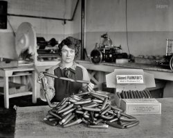 1927. "Skinned frankfurts, made in Washington, D.C." What Bismarck said about laws and sausages: It turns out you can watch them (or not watch them) being made in the same place. Harris &amp; Ewing glass negative. View full size.
I never sausage a messAnd where are your gloves, ma'am?
Delicious!They still make these, they're called "Old Fashion Hot Dogs", and can be found in some exclusive butcher meat markets. They explode with juice when you bite them! 
Wise Men SayThat anyone that worked in a sausage  factory never ate one again.
FranksIf you are from New York City, the correct pronunciation is FRANK-FRUTTER.
I Guess I Was Wrongbecause I thought baloney was the only product coming out of Washington!
Wipe that grin off your face mister.Sadly, Margaret was the only one who could even mention her job title of "Wiener Inspector" with a straight face.
YumI'll bet those didn't taste like mush the way modern frankfurters do.
Here..."Don't smile, just hold the sausages."
They probably had that good, old-fashioned fat content and were delicious.
The background machinery is a clueCould this be Mr. Dunderbeck's daughter?
MisattributedAttributed to Bismarck since the 1930s, the laws-and-sausages gem actually comes from the poet John Godfrey Saxe. 
Without a net!Or gloves.  Jaw desperately clenched against a retch as the eyes plead: "Don't buy these. Don't eat these. What has been seen in this awful place may never be unseen."
True, most modern franksdo taste and feel like mush. But if that's the only kind of hot dogs you know, you really should try a good, old-fashioned brand like Nathan's, Hebrew National, Sabrett, or Boar's Head. The meat for each of these is finely chopped, not emulsified, and the texture is completely different. Yuh-UM! I'm making myself hungry.
Her expressionHere is a woman who has heard ever wiener joke known to Man and is not amused.
(The Gallery, D.C., Harris + Ewing)