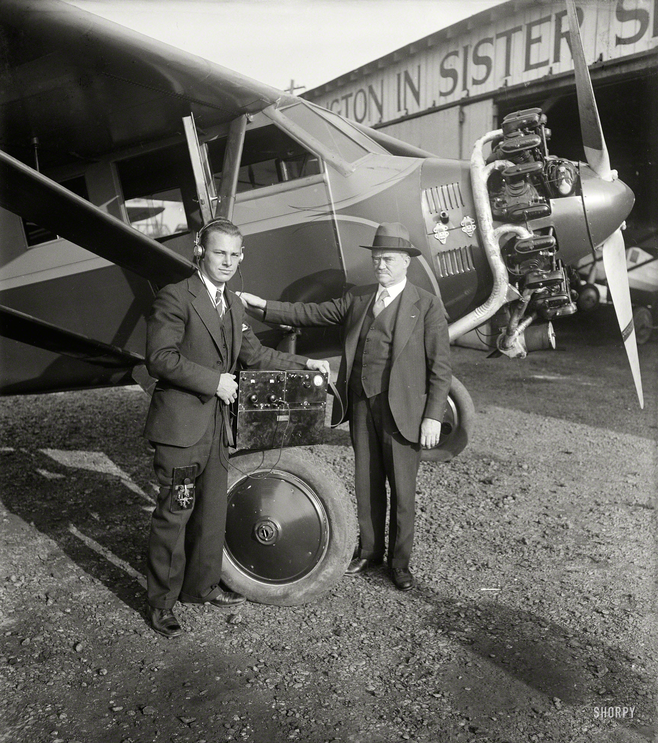 Dec. 5, 1929. Ignition interference from airplane engines on aircraft is largely a myth according to C. Francis Jenkins, Washington, D.C., inventor who has designed a radio receiving set which he says does not pick up noises from a flying power plant. In this photograph is shown Mr. Jenkins (right) and his laboratory assistant.
Video pioneer Francis Jenkins, seen here last week, and an anonymous protege who has a telegraph key strapped to his leg. By our reckoning this counts as early mobile texting. Harris & Ewing Collection glass negative. View full size.
