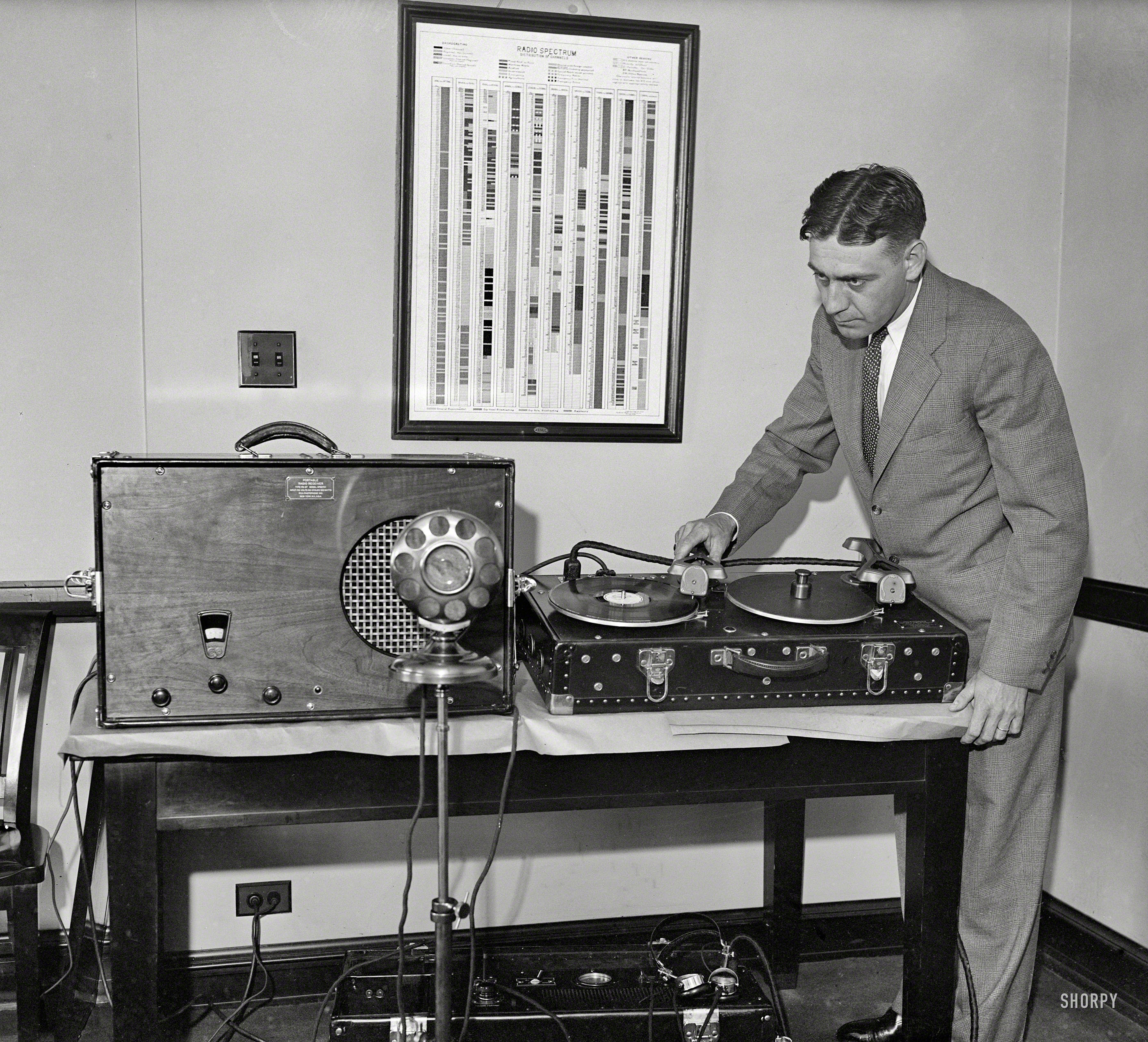 Washington, D.C., 1931. "Man with portable radio receiver and phonograph." Who seems to be using the amplifier to play a record into a microphone. Note handy "Radio Spectrum" chart. Harris & Ewing glass negative. View full size.