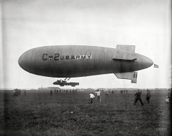 C-2 Army blimp makes record flight through fog and storm. Photographed upon arrival at Bolling Field. A powerful searchlight helped guide the craft through heavy fogs.-- Washington Post, July 29, 1922
July 1922. Washington, D.C. "C-2 dirigible at Bolling Field." The mystery aircraft first seen here. A few months later it met a fiery end in a hangar explosion in Texas. Harris & Ewing Collection glass negative. View full size.