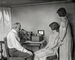 More on Dr. Jenkins here and here.
1925. "Motion pictures by radio are very near, predicts C. Francis Jenkins, who has designed this small radio-vision receiving set for use in the home. It is only a few inches square and is attached to the regular radio receiving set. A miniature motion picture screen is placed on the wall of your home, as shown in this photo. The first of this machine to be made. The photo was taken in Mr. Jenkins's laboratory at Washington, D.C." Harris & Ewing glass negative. View full size.