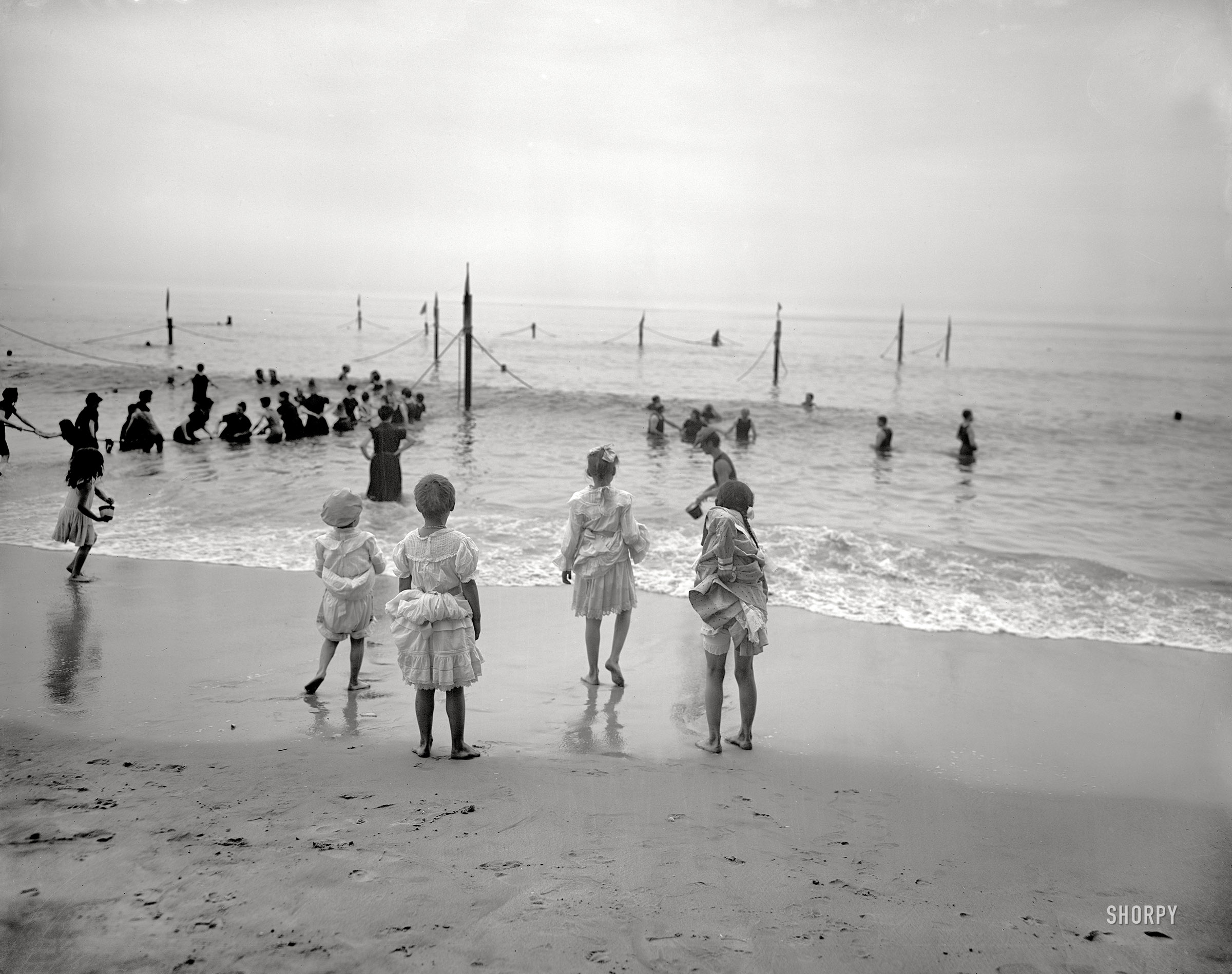 Circa 1905. "On the beach at Coney Island." The bathing-costumes this season are even skimpier than last year's. 8x10 inch glass negative. View full size.