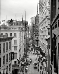 Circa 1905. "Nassau Street, New York City." So, $3.50. By the hour? By the pound? Oh wait. Per pair. Detroit Publishing glass negative. View full size.
Damn inflation.Today those women would be $88.07.
93 Nassau StreetThe white cast iron building on the right is 93 Nassau Street and it is still there. The view is looking south, towards Wall Street. Broadway is one block west. The World Trade Center was two blocks farther west from Broadway.
Commercial Cable BuildingThe domed tower at the end of the vista (but not the end of the street) is the 22-story Commercial Cable Building, built 1896-1897 to the designs of Harding and Gooch. It stood at 20 Broad Street, right next door to George B. Post's Stock Exchange (a small sliver of which is visible just below it). The Commercial Cable was demolished in 1954.
Hanover BuildingNorth of the Cable building is the Hanover Bank Building (1903) demolished to make room for the Bankers Trust annex tower (1931).
Bring money if you want to live thereThe building just to the right of center, with the rounded corner, is another one still around today.  It is known as the Fulton Building and has an address of 130 Fulton Street.  When it was built in the mid-1890's it was one of the last Manhattan office buildings constructed with load-bearing masonry walls as opposed to the steel frames that soon became universal.  
The Fulton Building was converted into residential condominiums in 2005, one of many office-to-residential conversions which occurred about that time in lower Manhattan.  This wasn't terribly good timing for buyers, as within a couple of years they found themselves living next to the massive Fulton Street Transit Center construction project.  Not that market value has suffered too much, as units are selling at upwards of $1.5 million.
Hanging or MeditationCorner window of Fulton Building's 3rd floor (?) is a gentleman either looking out, thinking, or hanged.
1/4 Sizes!From The Daily Standard Union (Brooklyn), March 22, 1907.  In tiny text, under Men's Stores in NYC, the first item in the listing is 102 Nassau St. at the corner of Ann St.
Predecessor to the $5 footlongRegal Shoes ads from that decade help to explain the odd juxtaposition of "women" and "$3.50." Regal's business model was positively 20th century: sell most of your products for a flat, highly-publicized price ($3.50), open up new branches like crazy, and deliver to the rest of the masses by mail. What was less modern was the company's use of gender-specific stores. Woe to the lady who was attracted to the Ann &amp; Nassau location by the "WOMEN" sign overhead. According to a 1906 ad in the Brooklyn Daily Eagle, Regal's store at Ann &amp; Nassau sold men's shoes, and its closest ladies' shoe store was at 785 Broadway.
(The Gallery, DPC, NYC)
