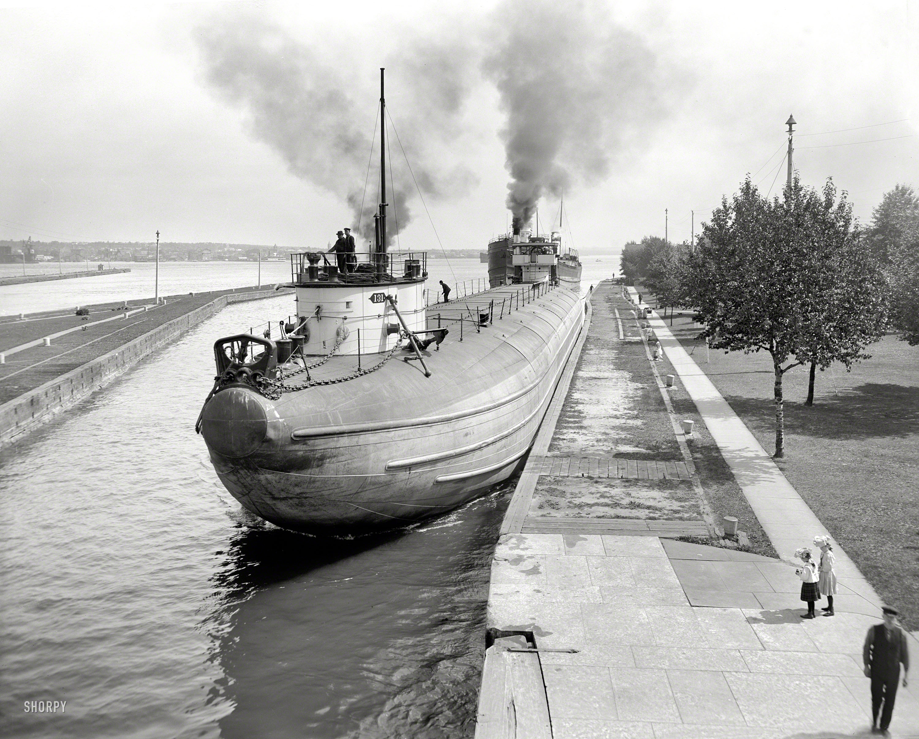 Circa 1910. "Whaleback barge entering Weitzel Lock, Sault Sainte Marie, Michigan." 8x10 inch glass negative, Detroit Publishing Co. View full size.