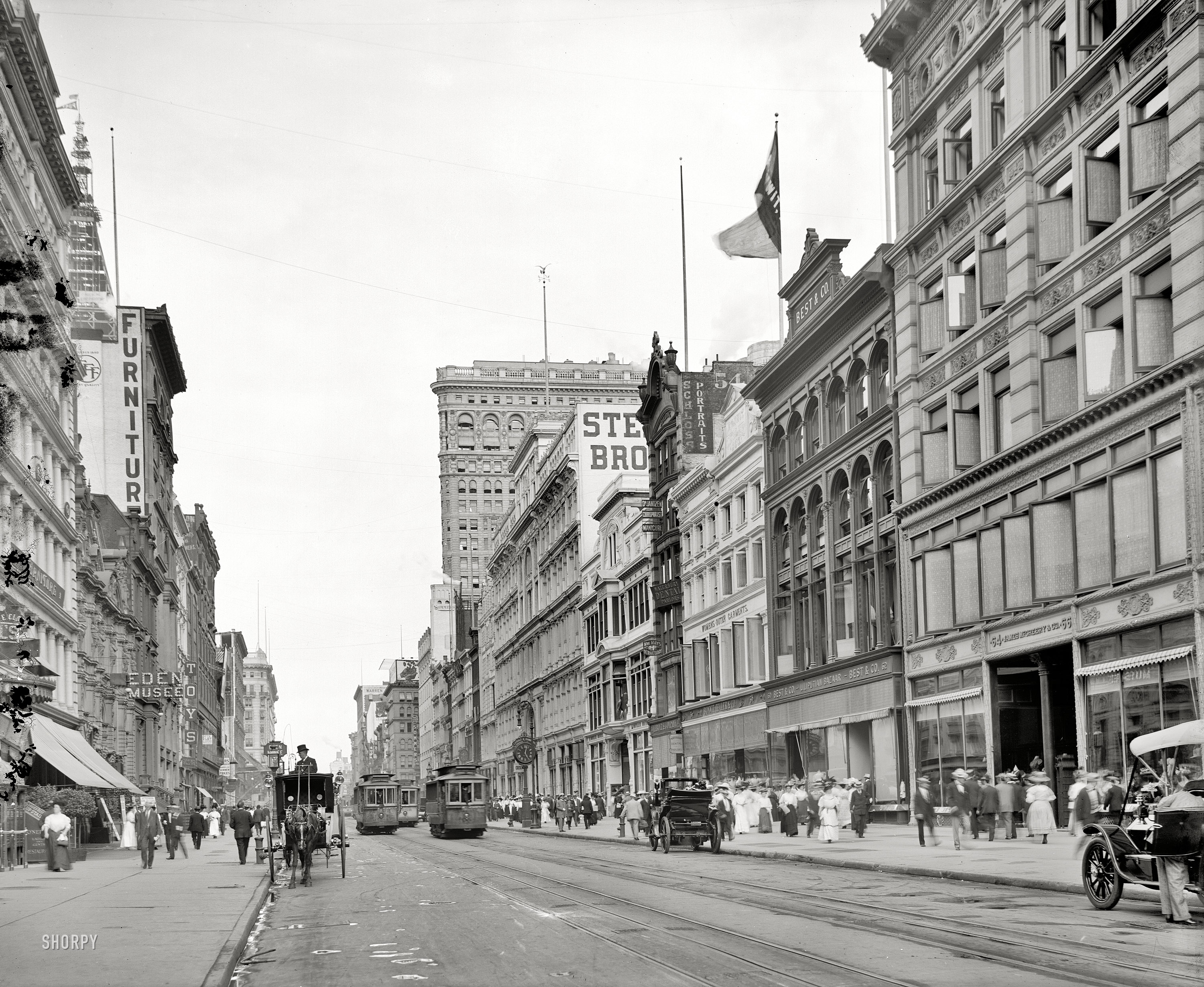 New York circa 1908. "West 23rd Street from Sixth Avenue." Two landmark skyscrapers on view -- the Flatiron Building at right and Metropolitan Life tower going up at left. At No. 62: The Best & Co. "Liliputian Bazaar." View full size.