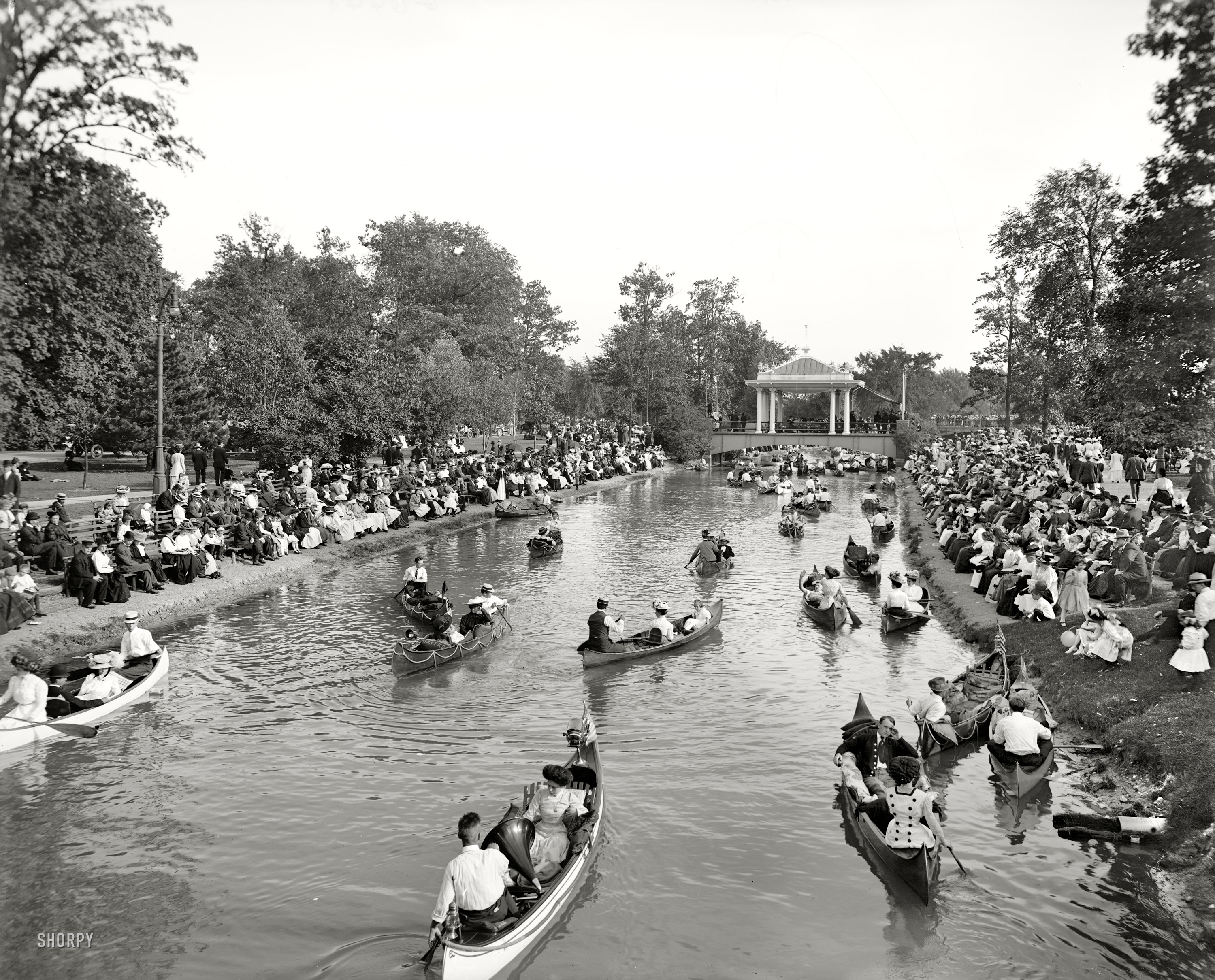 Detroit circa 1907. "Band concert on Grand Canal, Belle Isle Park." Once upon a time it might have been possible to woo a girl with just a humble canoe, but now you need plush pillows and a phonograph. 8x10 glass negative. View full size.