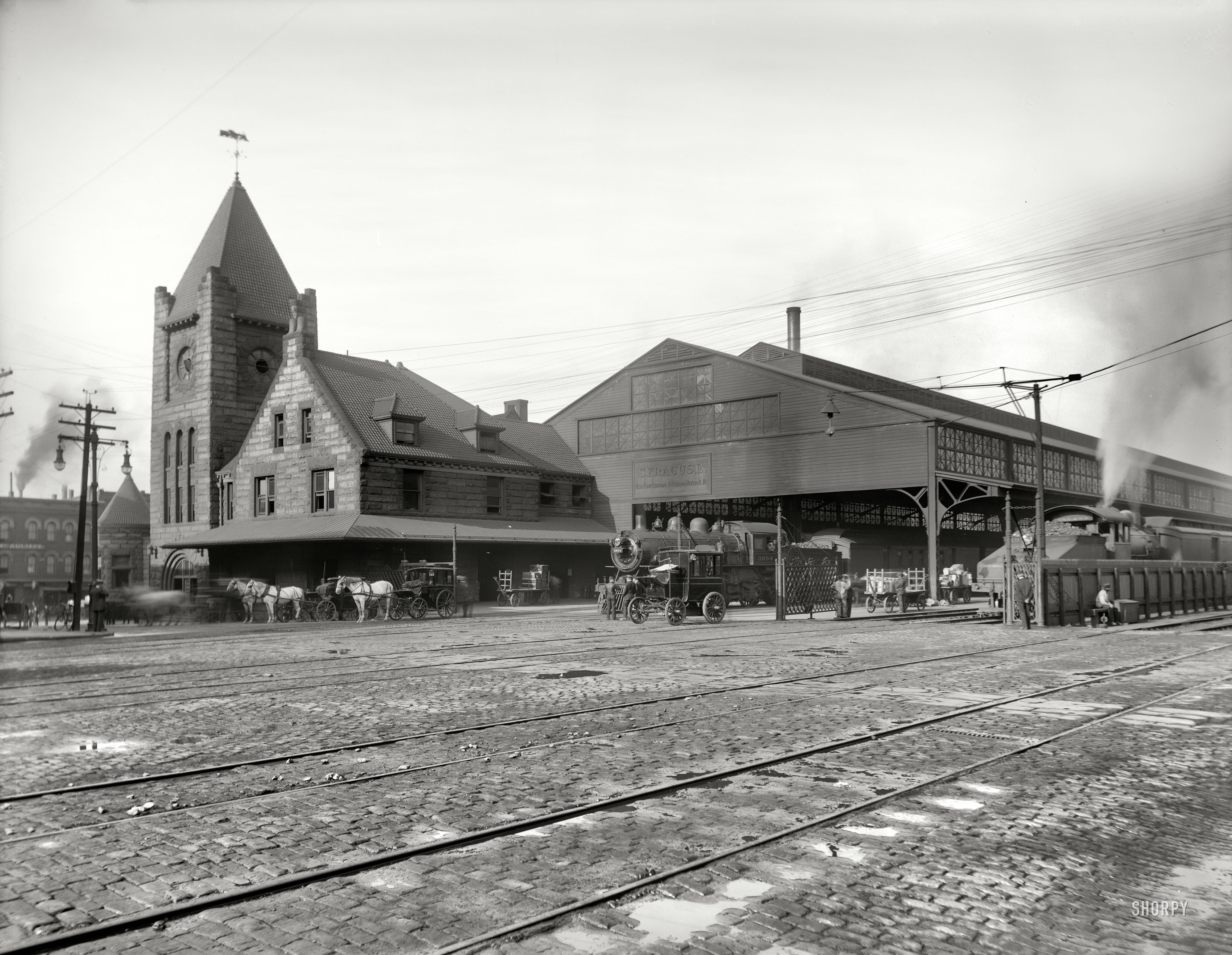 Syracuse, New York, circa 1905. "New York Central R.R. depot." Locomotive sharing the spotlight with an electric brougham. View full size.