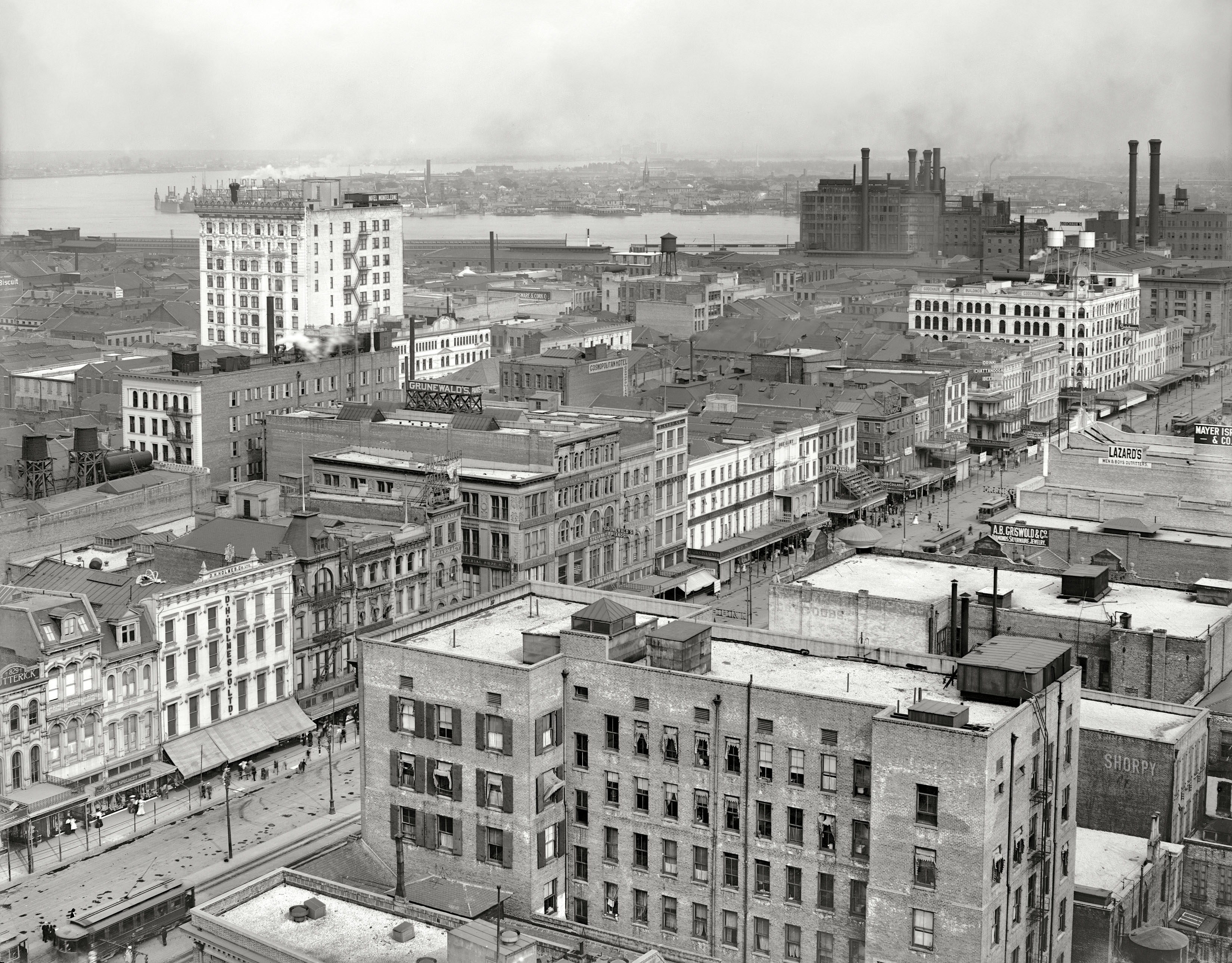 Circa 1910. "New Orleans and the Mississippi River from Grunewald." A bird's eye view of Canal Street from the Grunewald Hotel. Merchants here include Godchaux's music store as well as the big Godchaux's department store farther down the street, D.H. Holmes Co., B. Cohn Dry Goods, Marks Isaacs Co. and a One-Cent Vaudeville theater. And if all this shopping has made you thirsty: Drink Chattanooga Beer. 8x10 glass negative, Detroit Publishing Co. View full size.