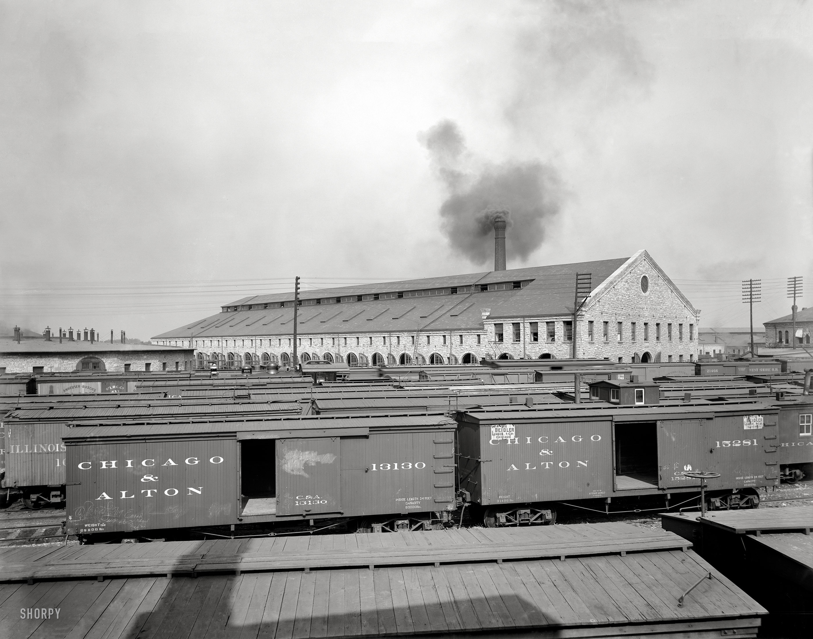 Circa 1904. "Chicago & Alton Railroad shops at Bloomington, Illinois." At left rear, the Anheuser-Busch beer boxcar. 8x10 inch glass negative. View full size.