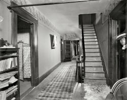 New Baltimore, Michigan, circa 1901. "The Firs -- upper hall." Our second look inside the Hatheway residence. Note the cloud of flash powder emanating from behind the stairs. 8x10 glass negative, Detroit Publishing Co. View full size.
The FirsSupposedly, the house was haunted and this photo is only adding to that. Rumor has it that Mabel Hatheway, daughter of the home's builder Gilbert Hatheway, died at age 20 in the house of mysterious circumstances. It was said that she "fell" down the stairs and broke her neck. There's also a rumor that she was buried in a glass coffin but who knows if that's true. 
September 6, 1901There's an American flag draped over the portrait hanging in the hall.  I wonder if this photo was taken shortly after the assassination of President McKinley.
Poor dogLooks like when Rover died they made a rug out of him. 
Haunted!But, but, there was no one in that room!!
Cue Twilight Zone music.
As a little kid.This place would be a constant source of fear for me as a kid.
1. Going up those stairs was certain death, as that is where the creepy mean guy lived.
2. Someone is bound to reach out and grab you into that first door on the left.
3. The next door down the hall, I'm sure someone is peeking out the crack between the door and the frame.
4. There is definitely a mad man hiding in the corner behind the open door ready to pounce.
5. Inside the far room, I can see the shadow of an axe murderer on the floor. Waiting. Waiting.
6. Down the stairs, worse than going up.
No way I could run fast enough to get to that door at the far end to escape.
Flash Powder?You don't know ectoplasm when you see it? And that's a werewolf-skin rug.
The flag is blocking glareI think the flag was put there to block the glare from the flash powder ignited behind the stairs.
Remote Flash?It looks like there were two flashes for this shot. One attached to the camera and the other behind the staircase. Looking at the shadows caused by the flashes seem to show this.
[You're right, although in this case both the one at the camera and the "remote" would have been guys holding the magnesium flash brackets and setting the powder off manually. - tterrace]
Flash SyncI've often wondered how the old timers obtained such well exposed images when the distance from the camera was so great.  Seeing the magnesium cloud suggests there were assistants as needed and the photographer opened the lens, gave a signal and they all set off the flash powder then he closed the lens.
What&#039;s in the bottle?Wonder what's in that mysterious uncorked jar on the sideboard? 
[Close-up, it doesn't look uncorked. I want to say the label reads "Furni[ture Polish] - tterrace]
That bottlemight contain Furniture Polish, or given the shape and style of the bottle and the fact that it was used in the period as an over-the-counter disinfectant, insecticide, and home remedy, it could contain Formaldehyde (or Formalin). Using the LoC original with contrast adjustments, my tired old eyes can't make a definitive case for the label reading either "Furni" or "Forma" (both are plausible), and the line below remains a tantalizing mystery. If only that bottle had been turned a few more degrees toward the camera.
[There certainly are similarities to this one. - tterrace]
(The Gallery, DPC)