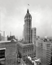 New York circa 1908. "The Singer Building." Shortly after its completion. 8x10 inch glass negative, Detroit Publishing Company. View full size.
Man on a LedgeI love looking at these big building and finding a man on a ledge cleaning windows. This time it looks to be the 7th floor at the right side.
So it goesIn the 70s, the New York city fathers saw the error of their ways and replaced this striking, beautiful building with a brown Modernist rectangle. Howard Roark would be pleased, at least.
(Trivia: the Singer Building was at the time the tallest building ever demolished.)
Obligatory rooftop laddersTwo, at least, on the ornate setback deck.
Still hold the recordIt still holds the dubious record as the tallest building ever intentionally demolished (I presume there's no need to explain the "intentionally" part).  As unfortunate as its demolition may be in retrospect, it was not at all surprising at the time.  The floors in the tower section were very small in terms of square footage, wholly inadequate for 1960's-style offices.
Today the obvious solution would be to convert the Singer Building into very expensive apartments.  Forty-five years ago, however, the idea of living in lower Manhattan would have struck almost everyone as strange to the point of absurdity.  You *worked* in the area, and at night it was a ghost town.  Things most definitely have changed.
Happy MealBentwood chairs, specifically the Vienna Cafe chair #14 was produced for "mass consumption" beginning in 1859. According to Carroll M Gantz' Design Chronicles, there were more than 50 million Vienna Cafe chairs produced by 1859 and the company had 52 European factories by 1900. So, it might be safe to say that in 1908 this type of dining chair was fairly typical. Looks like this family is prepared for a happy meal quite unlike the happy meals of today! 
(The Gallery, DPC, NYC)
