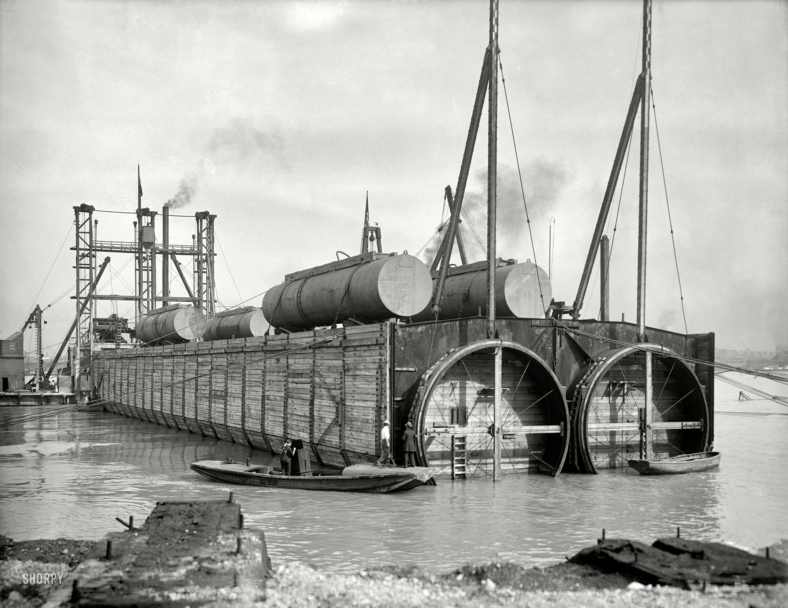 The Detroit River circa 1910. "Sinking last tubular section, Michigan Central R.R. tunnel. W.S. Kinnear, Chief Engineer, Butler Bros. Construction Co., contractors." 6½ x 8½ inch glass negative, Detroit Publishing Company. View full size.