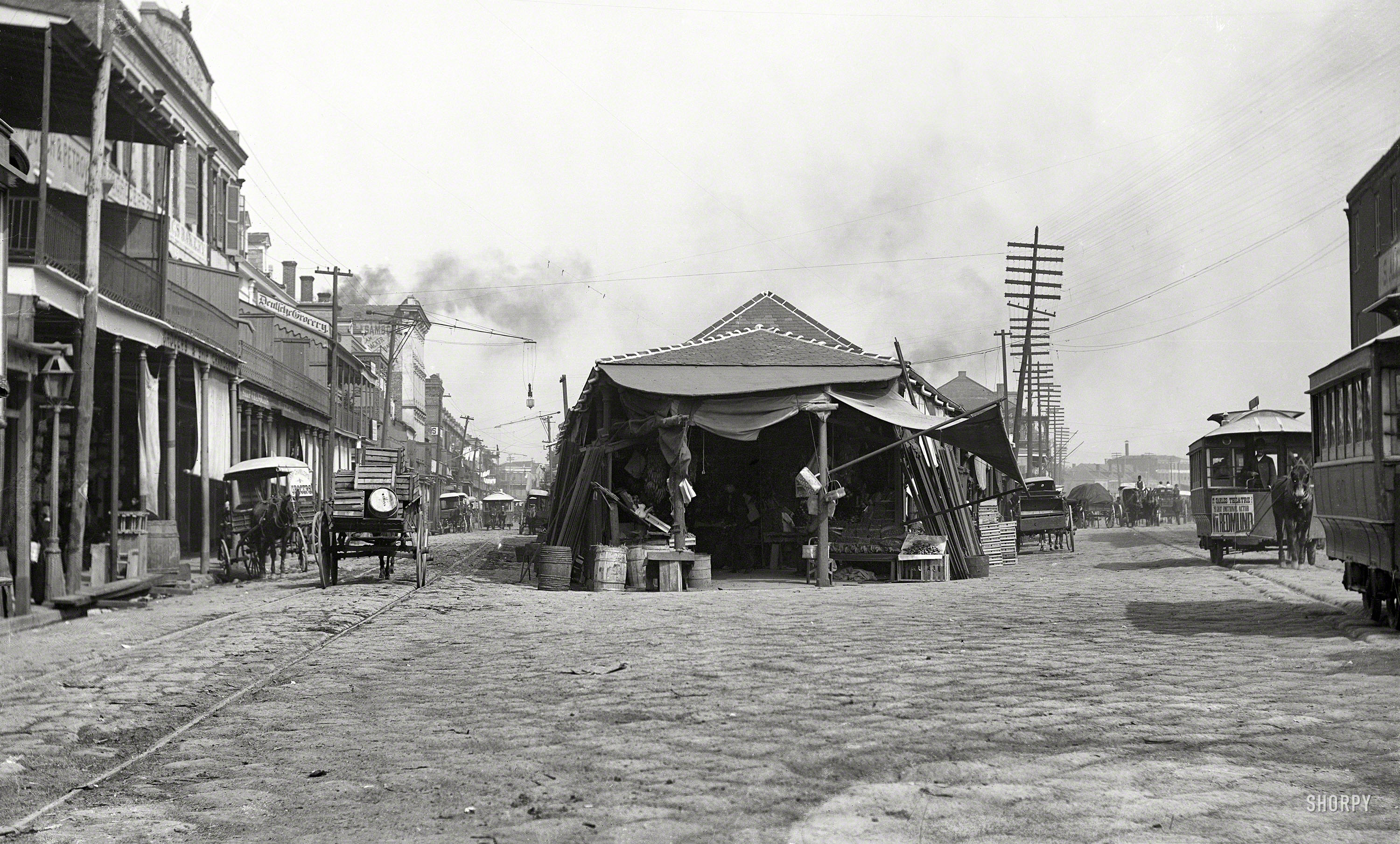 Circa 1890s. "The old French Market, New Orleans." Points of interest include many horsecars and an arc lamp on a boom. Ship Chandler's Grocer wagon and Deutsche Grocery at left. Photo by William Henry Jackson. View full size.