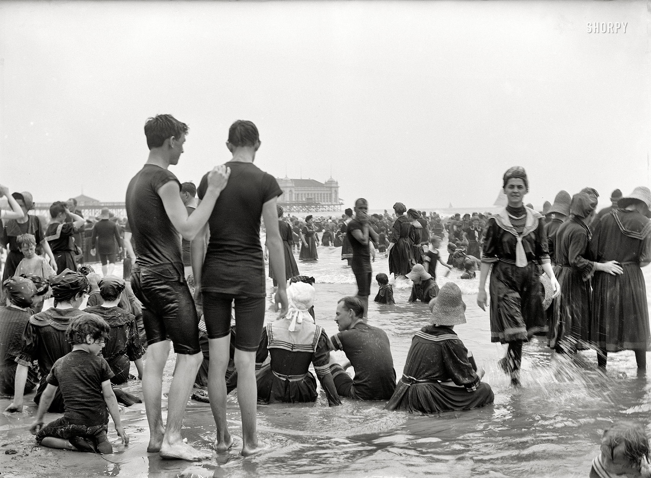 The Jersey Shore circa 1905. "Crowded beach, Atlantic City." These boys have been standing here for over an hour, hoping to spy a bare ankle. View full size.
