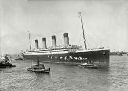New York. June 21, 1911. "White Star liner S.S. Olympic guided in by tugboats Geo. K. Kirkham and Downer." Detroit Publishing glass negative. View full size.
Luckiest woman in the worldAlthough Olympic's two sister ships Titanic and Britannic had tragic ends, Olympic's worst event in her 24-year career was her 1911 collision with the British warship HMS Hawke in the Solent (the strait between mainland England and the Isle of Wight) when her captain ordered a turn that caused a collision with the Hawke, much to the surprise of the Hawke's captain (who probably muttered "amateurs!"). Repairs caused a delay in the completion of the Titanic and, when the all-better-now Olympic lost a prop blade sailing from New York in February 1912, a blade from the Titanic was used to replace the one that was lost, pushing Titanic's first/final voyage to three weeks later, very probably creating her iceberg collision destiny. The captain of both the Olympic during the Hawke wreck and the Titanic was Edward Smith (who died with Titanic).
The luckiest woman? That'd be Violet Jessop, a young woman who was a stewardess on Olympic when the Hawke collision  occurred, a stewardess who survived Titanic and, while serving in World War One as a Red Cross nurse, escaped from Britannic when she sank in the Aegean Sea after hitting (it's thought) a mine.  
By the way the rearmost (aftest?) smoke stack on all three of these ships was a dummy, to make the designs more balanced. The stacks were used for ventilation.  
Here's Nurse Jessop in her Britannic uniform.   
Too bad they scrapped it.It would have saved James Cameron a lot of CGI work.
Looks familiar because?Because the Olympic was a sister ship to both the Britannic and Titanic, and the smallest of the three, but not by a lot.  Olympic was the world's largest ocean liner between the time she was launched and 1934 or so, when the Queen Mary came into service, except for during the very brief careers of the two sister ships.  Everyone knows about Titanic.  Britannic was launched right about as World War One was starting up, and never served as passenger ship.  She was put into service as a hospital ship, and struck a mine near Greece in 1916 and sank.
RMS OlympicGoogle-Wiki has a very informative article on this ship.  For instance, like the Titanic, when she first went to sea she was equipped with twenty lifeboats, enough for half the people on board.  When White Star received public condemnation for this after the Titanic disaster, it scurried around and secured additional, second hand, collapsible lifeboats from troop ships, for the Olympic.  Some were rotten and could not be opened.  'And so they went to sea once more, "Sensation" they for aye forswore.'  (Apologies to W.S. Gilbert.)
In 1918, she sank the U-103, that was attempting to torpedo her, by colliding with it.
http://en.wikipedia.org/wiki/RMS_Olympic
http://www.youtube.com/watch?v=x6dB2RA8Kno
Not the largest ship in the world for longThe Olympic class liners were quickly outclassed. 
http://en.wikipedia.org/wiki/SS_Imperator
The three Imperator class ships also had far improved interior volume then any ship previous including the Titanic.  They were the first ship to break up the exhaust into many smaller pipes.  On the Titanic the funnel casing ran straight up the middle of the ship.
She Carried The MailBecause she was equipped and certified to carry the mail, Olympic's actual title (like Titanic) was not 'SS' (Steam Ship) but 'RMS' (Royal Mail Ship). Sister Bitannic was an HMHS (Her Majesty's Hospital Ship).
Many old photographs and film mistakenly identify Titanic but are in fact Olympic. The way to tell the difference between the two is the open promenade deck (below the boat deck) as seen here on the Olympic, which was enclosed on Titanic after Olympic customers had complained of the cold there.
According to author Walter Lord, after the Olympic was decommissioned in 1935, her interior wood panelling was sold off and used to decorate the interior of British pubs. 
Not Her Majesties Hospital Ship BritanicSince it was the Edwardian era, it would have been His Majesties Hospital Ship Britanic.
Running on 4 Cylinders?It is well known that No. 4 funnel on TITANIC was a dummy, and also that the three "sister ships" were not true sisters but differed in a number of respects, including principal dimensions; they might not be called sisters were they in existence today.
In this photo it looks to me like there is smoke coming out of No. 4 funnel, which in the most famous sister was a dummy.  Does that mean this was a "real" funnel in OLYMPIC?  Smoke is plainly to be seen above No. 1 and 3, with maybe a tiny wisp above No. 2.  Isn't it at least a little odd that all boilers seem to be active as the ship is just maneuvering into harbor?  While the ship's engines would be used in docking, with tugs to help, it doesn't seem that full power would be needed and letting some boilers cool off would be more economical of coal.
Is it possible the photo was touched up to show smoke where there was none in reality?
Smoking RoomThe aftmost stack was a dummy as far as the main boilers were concerned, but was still used for ventilation of other machinery - 'donkey' engines, cooking smoke, et c.
Olympic &amp; TitanicThe two were sister ships. They were built to the same plans. Britannic was the most different of the three. The Olympic &amp; Titanic had the exact same dimensions. Titanic simply had more enclosed space than Olympic, which was factored into her gross tonnage figures (tonnage was not weight, but a measurement of internal space) and made her the "largest" liner in the world.
Olympic was the world's largest ship for about two years (discounting Titanic's brief reign) until the Imperator came out in 1913. 
The dummy funnel was used for ventilation and also exhausted smoke from the galleys.
Full power could still be needed while moving into port, so I doubt they would begin shutting down boilers at this point. The Hudson has very strong currents.
(The Gallery, Boats & Bridges, DPC, NYC)