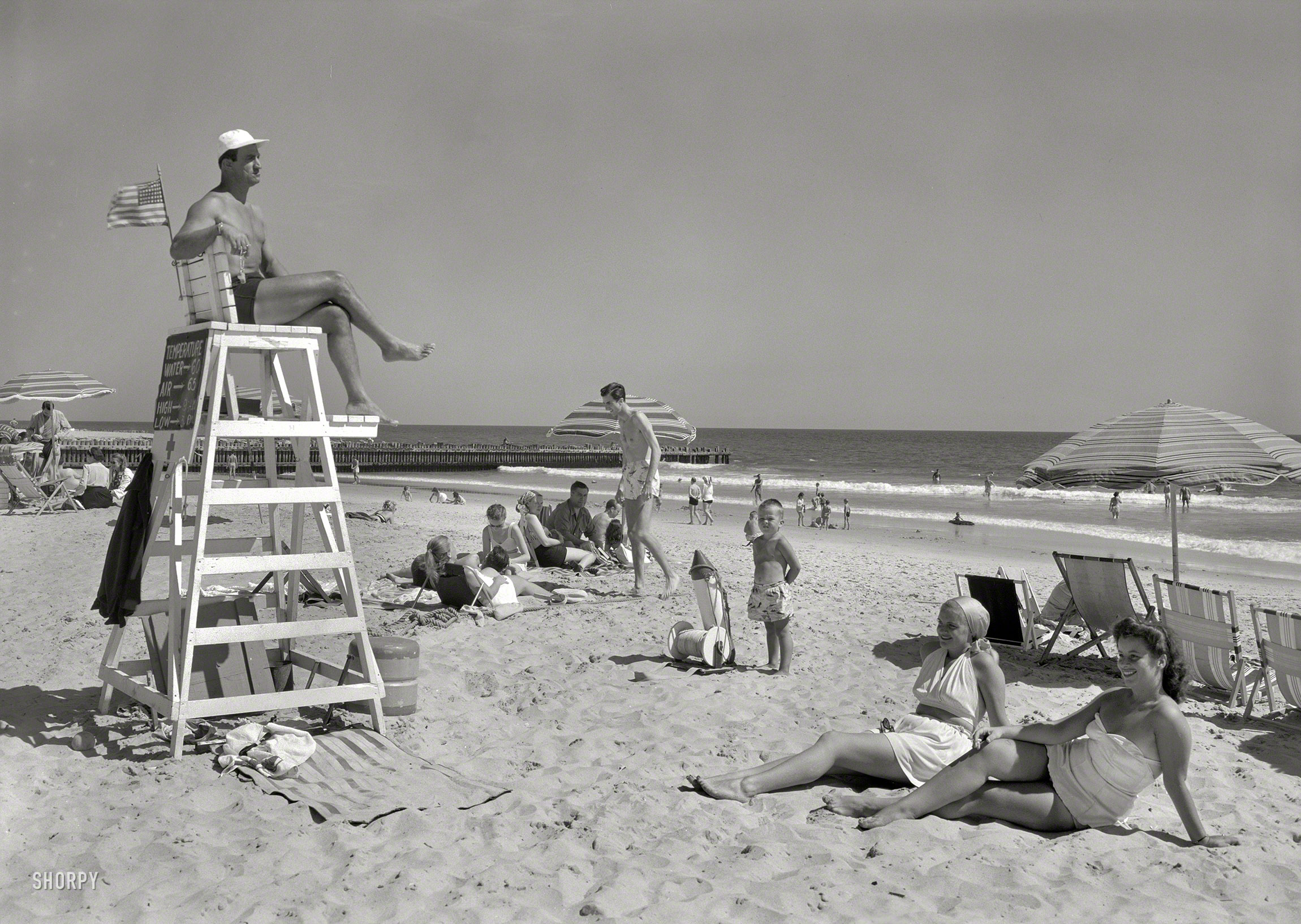 August 1, 1947. "Surf Club, Atlantic Beach, Long Island, New York. Beach scene III." Ever alert for signs of distress, the lifeguard must have a keen sense of peripheral vision. Gottscho-Schleisner photo. View full size.