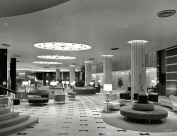 March 30, 1955. "Fontainebleau Hotel, Miami Beach. General view of lobby. Morris Lapidus, architect." Gottscho-Schleisner photo. View full size.
The Streets of MiamiI'm guessing this is the same place that Allan Sherman mentioned in his song "The Streets of Miami". "I'm going to the Fontainebleau / Pardner, it's mod'ner."
Opulent ExtravaganzaIf you thinks the lobby was something, take a gander at the building itself. A midcentury postcard is attached.
Tres classyAll those Roman statues and busts make me want to drink tea with my pinky sticking straight out.
And the title of the architect&#039;s autobiography is"Too Much Is Never Enough," by Morris Lapidus (1996). This is a sly reference to the motto attributed to Ludwig Mies van der Rohe, "Less is more" (even though he never actually said that, in English or in German). 
GoalLapidus always tried to make ordinary visitors feel extraordinary.  He wanted the guests to feel like a Cary Grant or a Grace Kelly while they were in this hotel.  To transport them to someplace 'special' and well removed from their normal lives. 
Clearly a Staged PhotoNo ashtrays. (Well, maybe one -- see if you can find it).
Best of both worldsThis lobby manages to be elegant and sophisticated yet tacky and cheesy.  I like it and I don't.
(The Gallery, Florida, Gottscho-Schleisner, Miami)