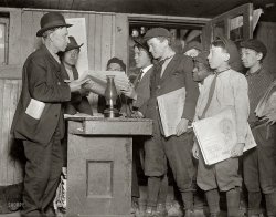May 1910. St. Louis, Missouri. "Burns Basement Branch. A dark dirty cellar, 3518 Evans Avenue." Newsies picking up their papers from the St. Louis Times news agent. Photo by Lewis Wickes Hine. View full size.