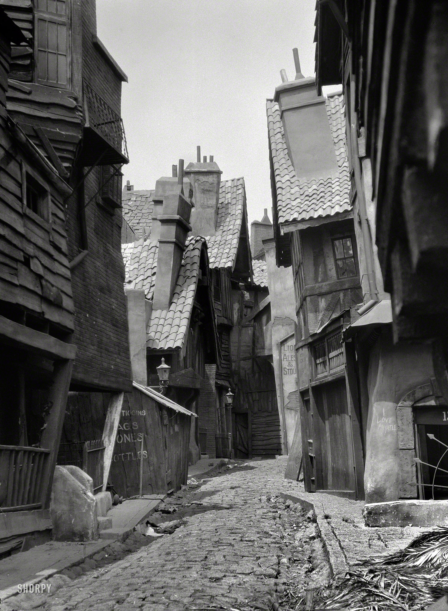 Circa 1920. "Unidentified buildings, possibly movie set, associated with Famous Players-Lasky." This seriously askew alleyway has a Dickensian-Disneyesque vibe. (Also: "I love Myrtle.") Nitrate negative by Arnold Genthe. View full size.