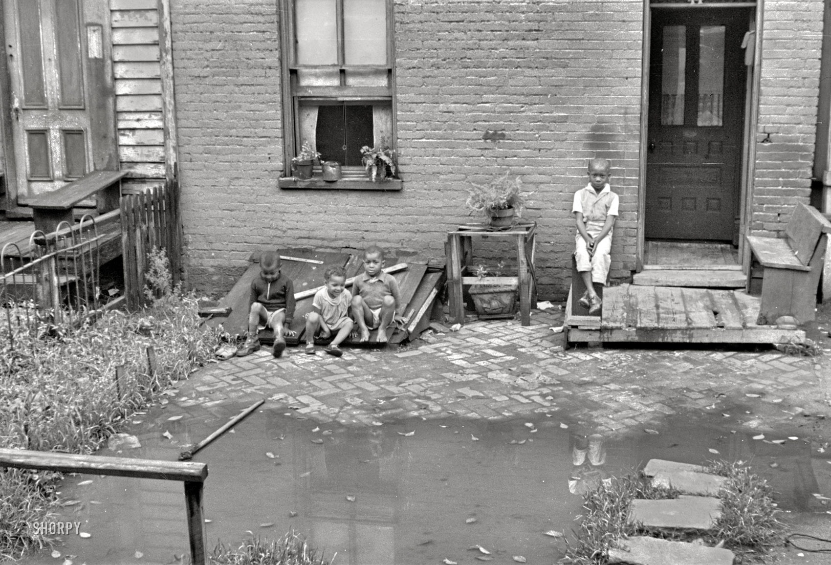 September 1935. A closeup of the Washington, D.C., row house seen here over the weekend. "Front of old brick structure in section near Union Station. Land is low here and water collects in front and backyard after a rain and remains for many days. Entrances to privies are usually under water. Interior of homes similar in shabbiness to exterior." 35mm nitrate negative by Carl Mydans for the Resettlement Administration. View full size.