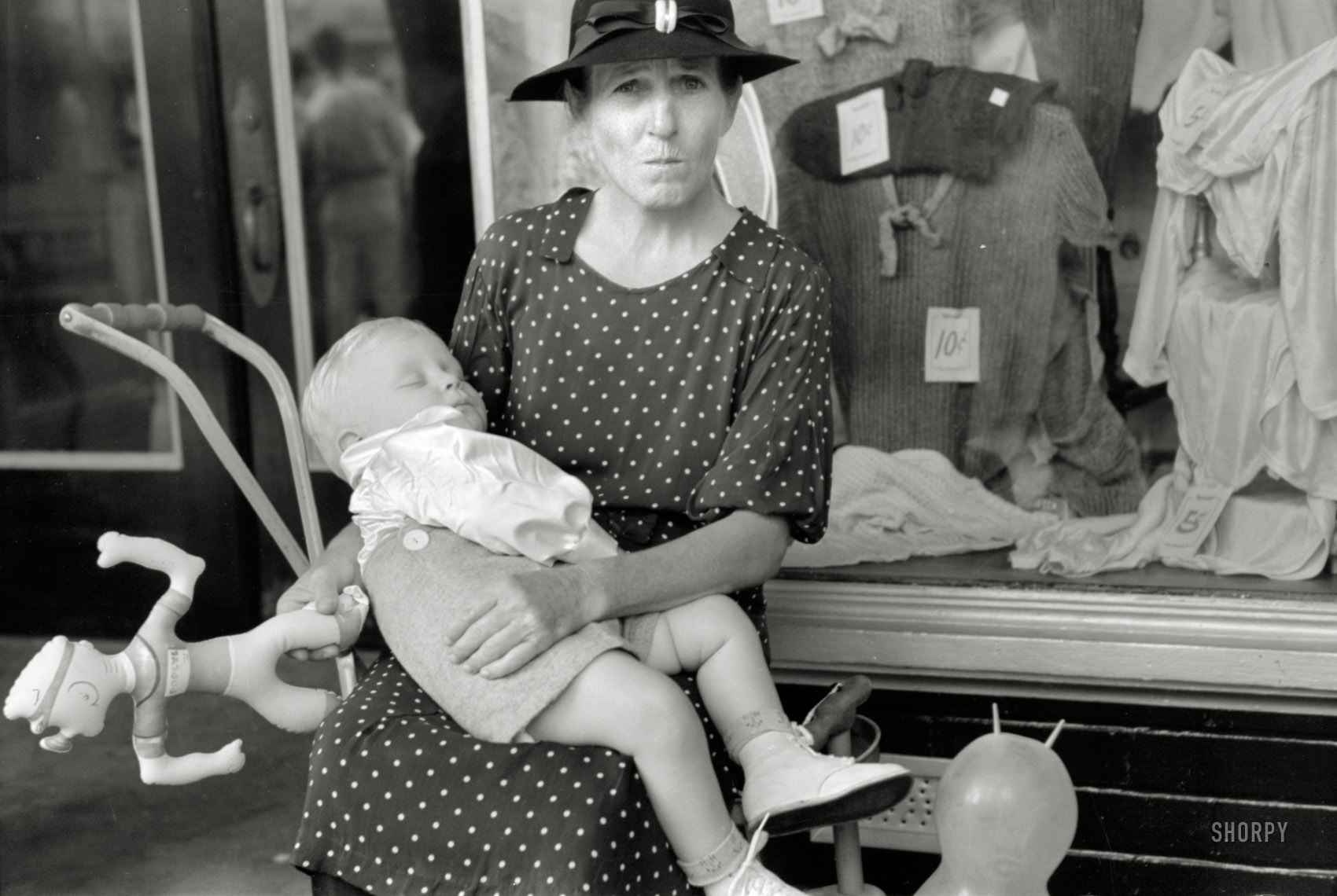 October 1938. Crowley, Louisiana. "Woman with child in front of store during National Rice Festival parade." After the spinach ran out. 35mm nitrate negative by Russell Lee for the Farm Security Administration. View full size.