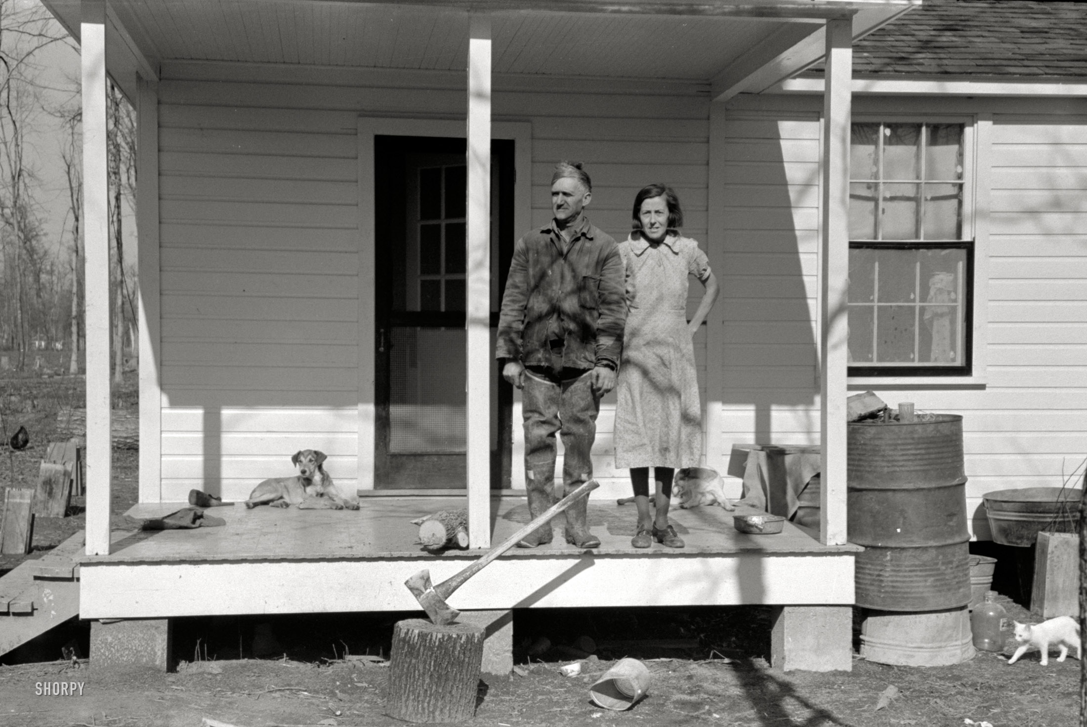 January 1939. Chicot Farms, Arkansas. "Husband and wife on porch of farm house." Photo by Russell Lee, Farm Security Administration. View full size.