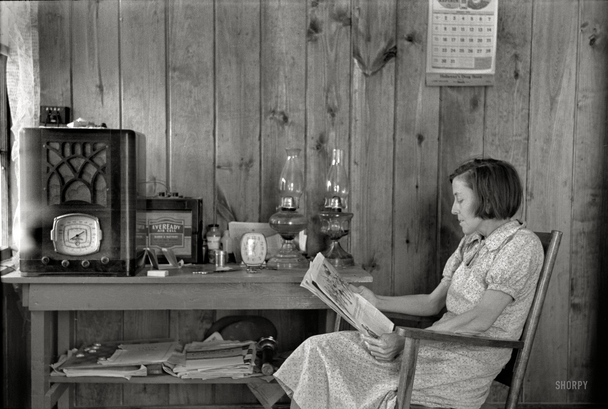 January 1939. "Housewife reading in living room. Chicot Farms, Arkansas." A peek behind the porch seen in the previous post. 35mm nitrate negative by Russell Lee for the Farm Security Administration. View full size.