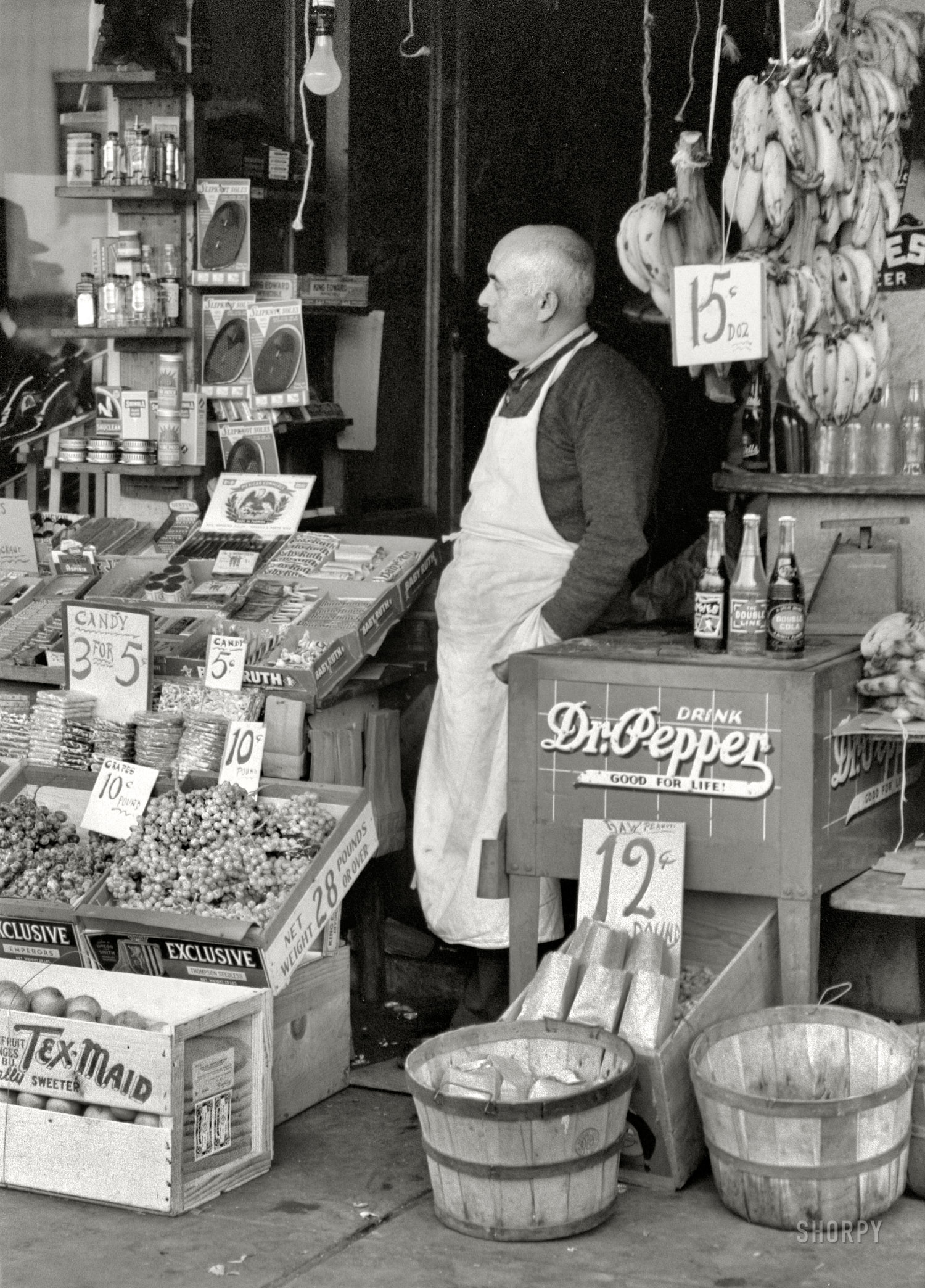November 1939. Waco, Texas. "Proprietor of small store in market square." Pop bottles on the cooler: Woosies, Double Line and Double Cola. 35mm nitrate negative by Russell Lee for the Farm Security Administration. View full size.