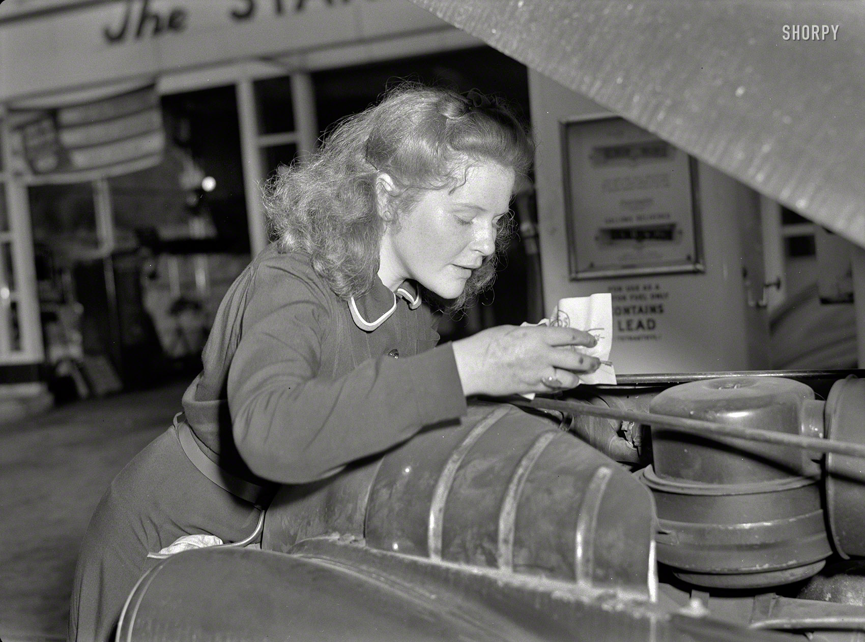 September 1942. "Tires need checking too? Shifting trends of employment in wartime America have opened up new jobs for women such as this young East Liverpool, Ohio, girl who has pioneered in two new fields since graduation from high school. She learned butchering first, and built up quite a reputation as a purveyor of choice cuts. Now she's one of the most efficient service station attendants in the neighborhood. Her name? Virginia Excell." Photo by Ann Rosener for the Office of War Information. View full size.