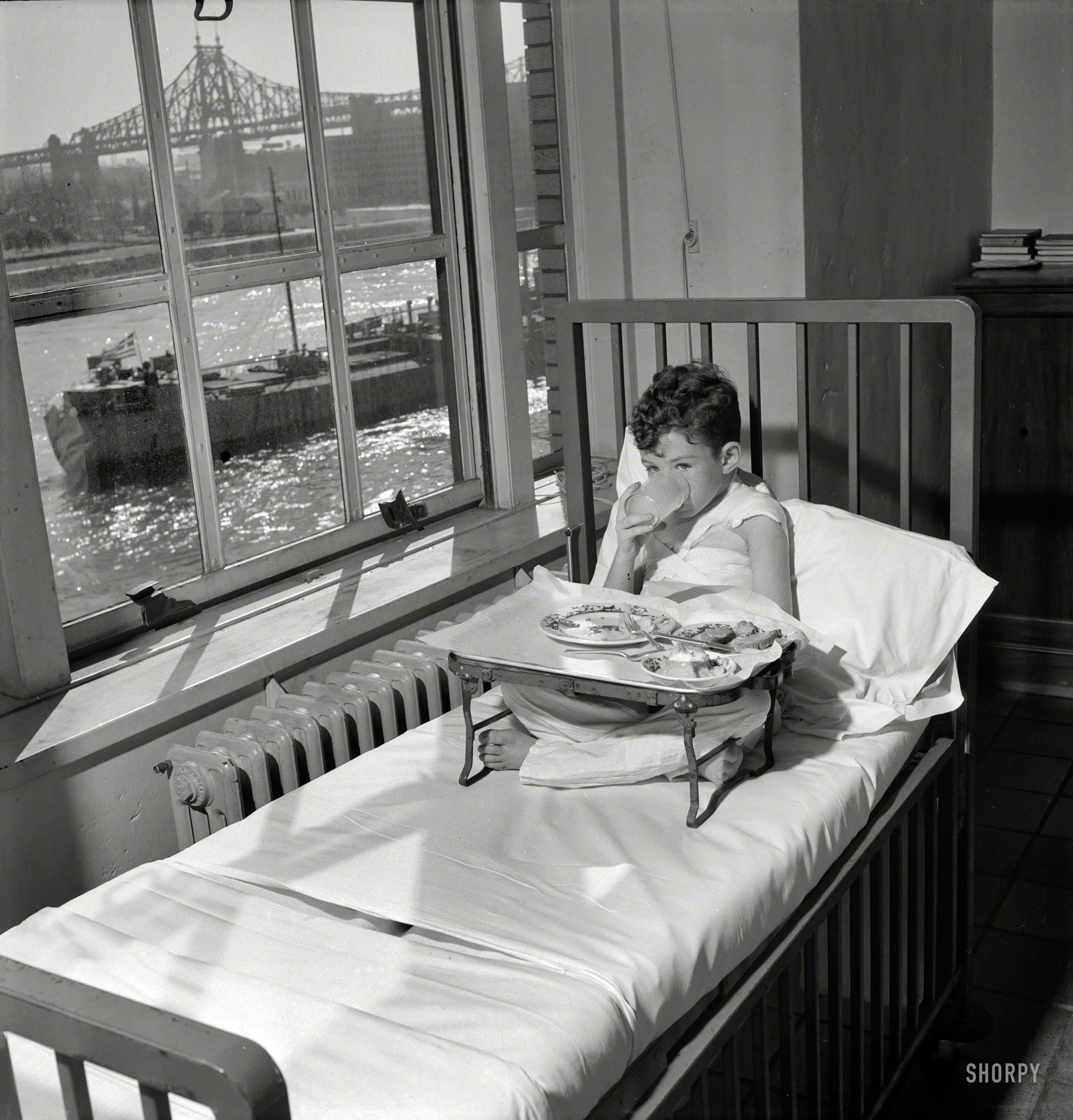 November 1942. "Babies' Hospital, New York. The welfare of this young patient, suffering from burns, is aided by having his bed placed near a window where he can watch the boats pass by. Nurses learn the importance of ministering the comforts of their patients in promoting recovery." Photo by Fritz Henle for the Office of War Information. View full size.
