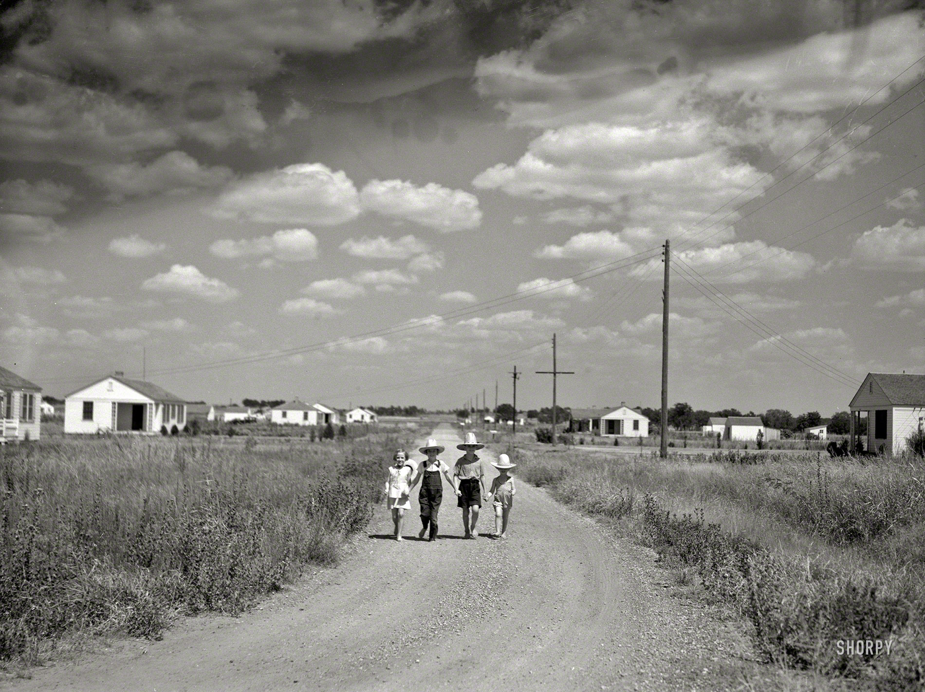 Summer 1936. "Dalworthington Gardens, Texas." Half-pints in ten-gallon hats in a "subsistence homestead project" established under the authority of the National Industrial Recovery Act. Photo by Arthur Rothstein. View full size.
