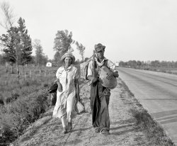 May 1936. " 'Damned if we'll work for what they pay folks hereabouts.' Crittenden County, Arkansas. Cotton workers on the road, carrying all they possess in the world." Photo by Carl Mydans, Resettlement Administration. View full size.
