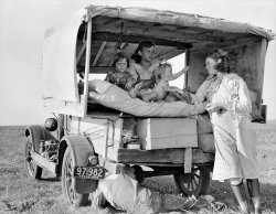 August 1936. "Family between Dallas and Austin. The people have left their home and connections in South Texas, and hope to reach the Arkansas Delta for work in the cotton fields. Penniless people. No food and three gallons of gas in the tank. The father is trying to repair a tire. Three children. Father says, 'It's tough but life's tough anyway you take it.'" Medium-format nitrate negative by Dorothea Lange for the Resettlement Administration. View full size.