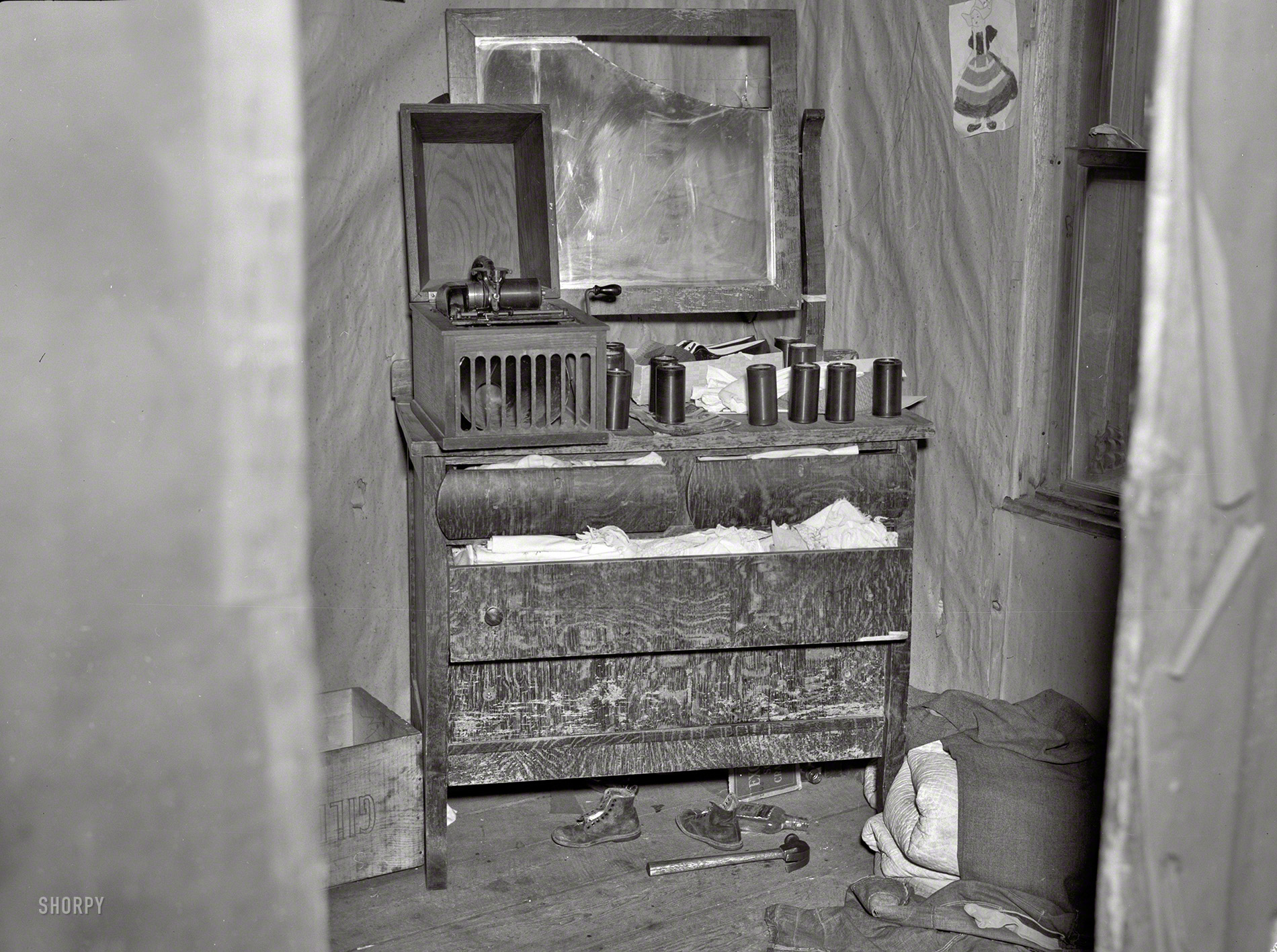 April 1937. "Bureau in the bedroom of the house occupied by the Ingrahams and the Smallwoods near Nelma, Wisconsin." A cryptic tableau if there ever was one. Medium-format nitrate negative by Russell Lee. View full size.