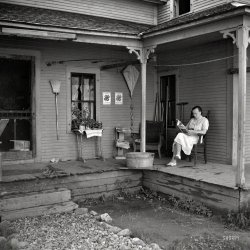 July 1940. "Reading on the front porch. Lincoln, Vermont." Homey props: Cat, kite, broom, washboard. Screen door! Photo by Louise Rosskam. View full size.