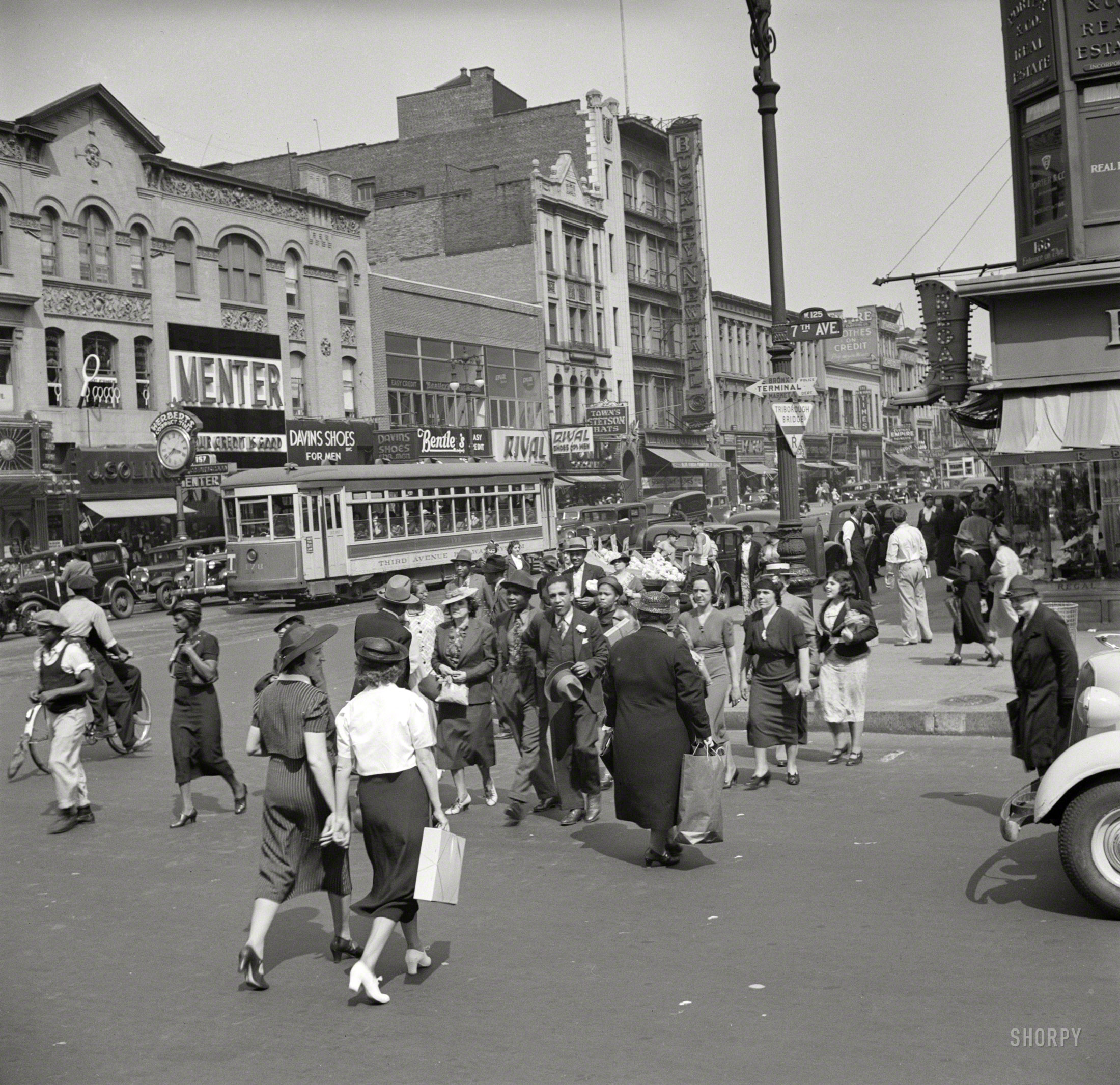 Summer 1938. "New York street scene, Seventh Avenue at West 125th." Fast-forward to 2013 and the Triborough Bridge sign would read "Robert F. Kennedy Bridge"; Seventh Avenue is now Adam Clayton Powell Jr. Boulevard; W. 125th Street is also known as Dr. Martin Luther King Jr.  Boulevard. Photo by Jack Allison for the Resettlement Administration. View full size.