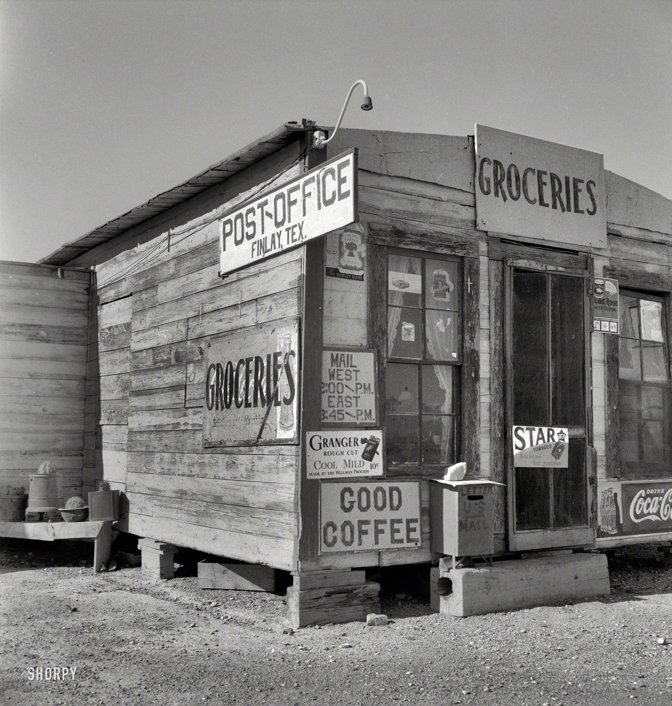 May 1937. "Post office. Finlay, Texas." Magazine, caffeine, nicotine -- all your basic ines. As well as potted cacti. Photo by Dorothea Lange. View full size.