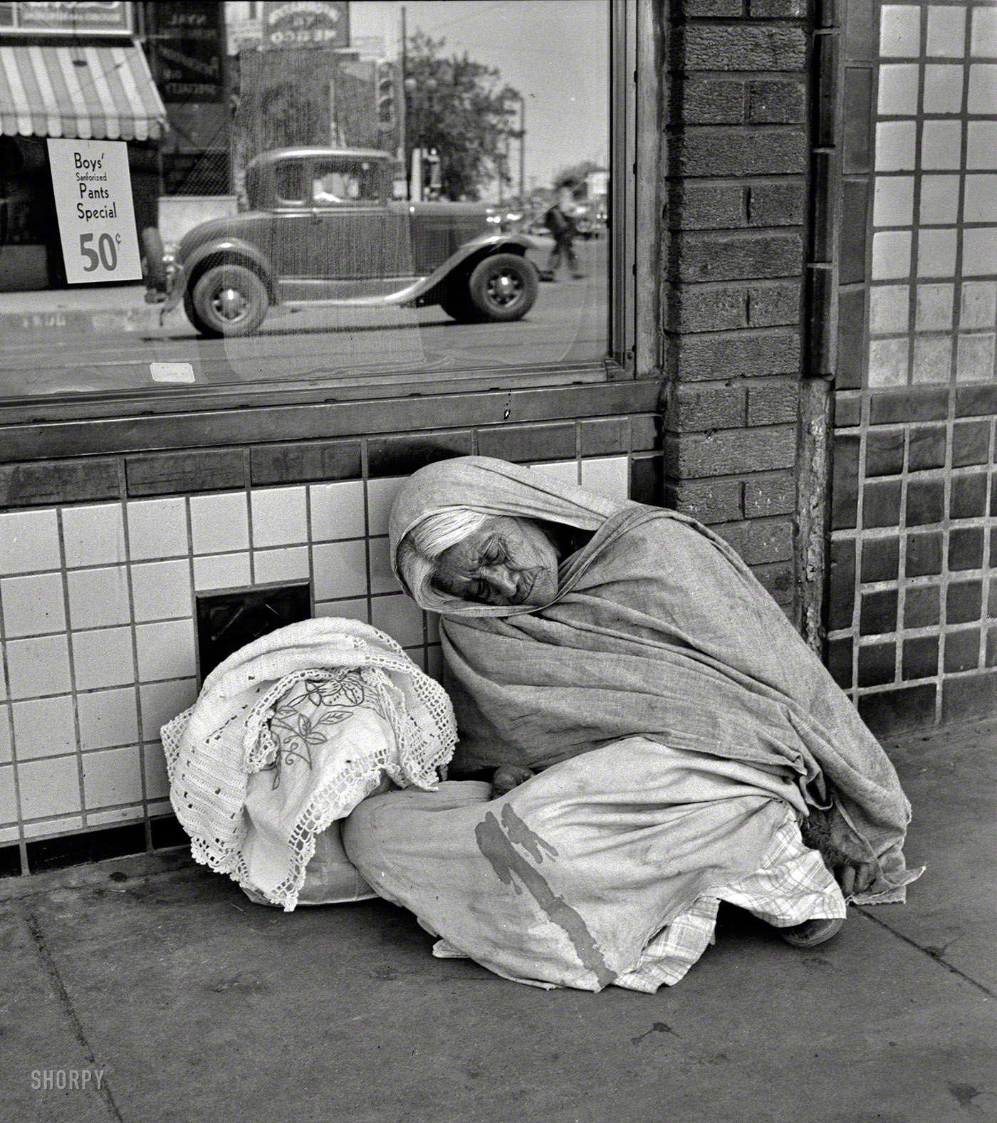 June 1938. "She awaits the international streetcar at a corner in El Paso, Texas, to return across the bridge to Mexico." Photo by Dorothea Lange.  View full size.