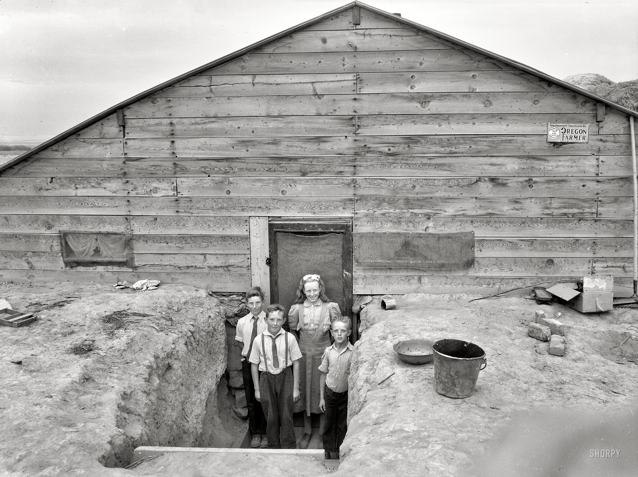 October 1939. "The Free children in doorway of their dugout home in Sunday clothes. Dead Ox Flat, Malheur County, Oregon." Medium format nitrate negative by Dorothea Lange for the Farm Security Administration. View full size.
