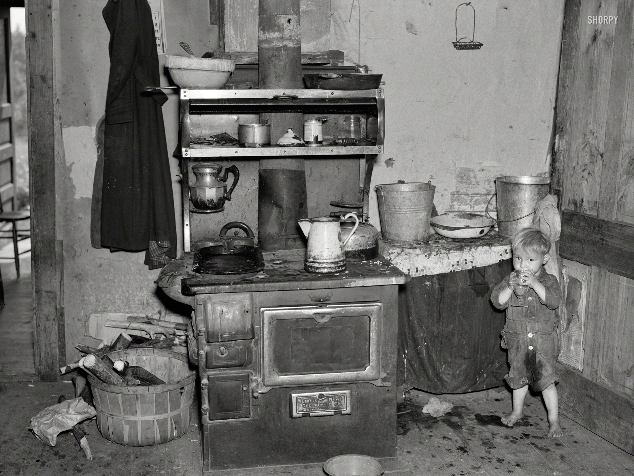 June 1937. "Child of Earl Taylor in kitchen of their home near Black River Falls, Wisconsin." Photo by Russell Lee, Resettlement Administration. View full size.