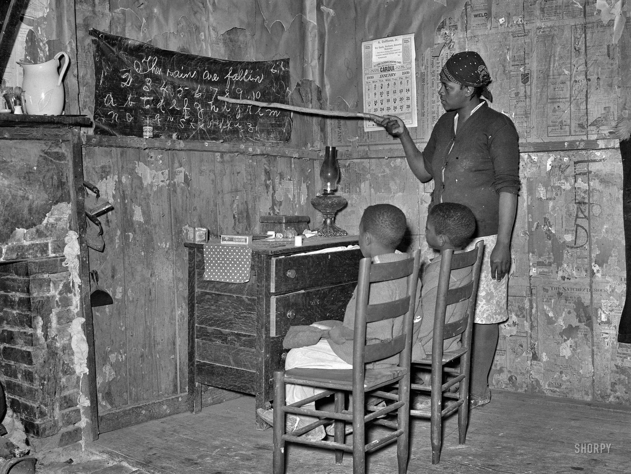January 1939. "Negro sharecropper mother teaching children numbers and alphabet in home. Transylvania, Louisiana." Medium-format nitrate negative by Russell Lee for the Resettlement Administration. View full size.