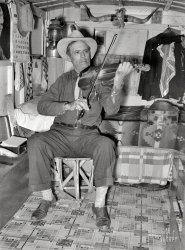 February 1939. "Mr. Bias, former cowboy, now travels around the country in a trailer. Has private income. Weslaco, Texas." What does Mr. Bias play? Why, he plays favorites! Photo by Russell Lee for the Resettlement Admin. View full size.
