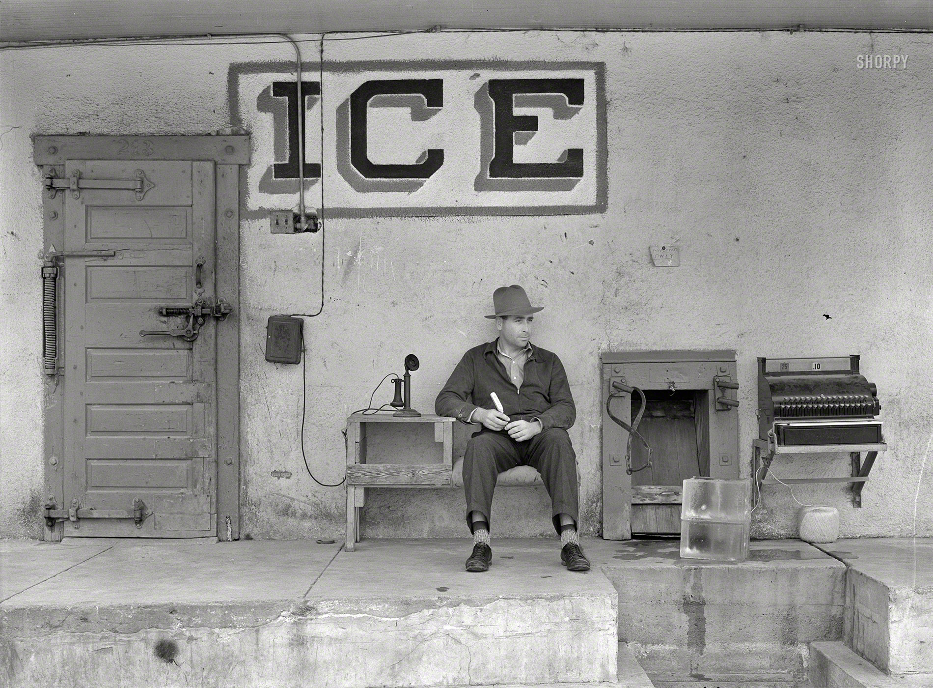 February 1939. "Ice for sale. Harlingen, Texas." Pointy pick? Check. Telephone? Yes. Cash register? Yew betcha. Ginormous ball of twine? Natch. Big block of you-know-what? Right here. Snazzy socks to seal the deal? Done and done. Looks like we are in the ice business! Photo by Russell Lee. View full size.