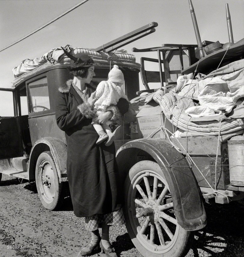 February 1937. "Tracy (vicinity), California. U.S. Highway 99. Missouri family of five, seven months from the drought area. Broke, baby sick, car trouble." Photo by Dorothea Lange for the Farm Security Administration. View full size.
