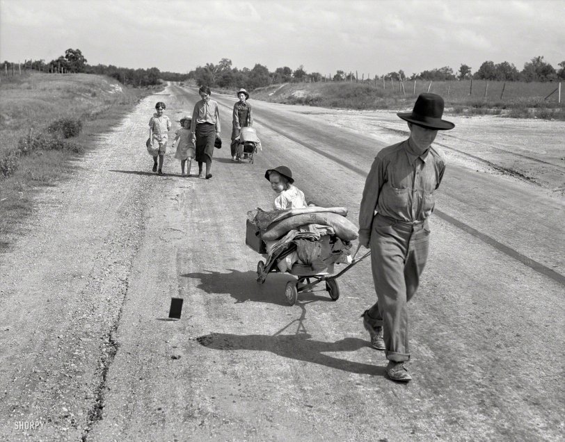 June 1938. Pittsburg County, Oklahoma. "Family walking on highway, five children. Started from Idabel, bound for Krebs. In 1936 the father farmed on thirds and fourths at Eagleton, McCurtain County. Was taken sick with pneumonia and lost farm. Was refused relief in county of 15 years' residence because of temporary residence elsewhere." Photo by Dorothea Lange. View full size.
