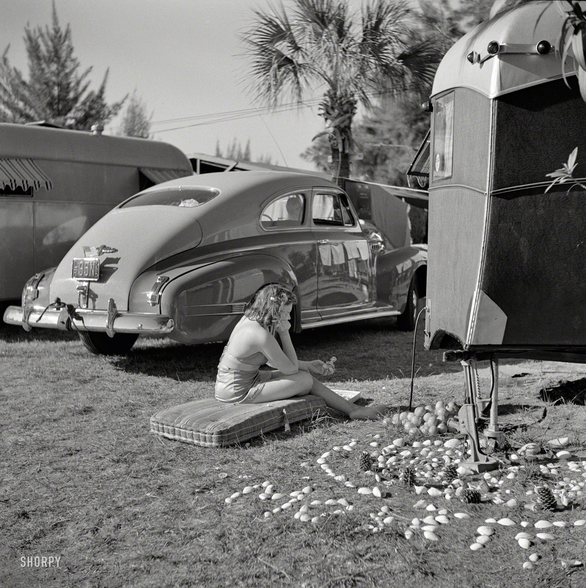 January 1941. "Guest at Sarasota, Florida, trailer park, beside her garden made of shells and odds and ends. The camp has garden club for members organized for the purpose of making the surroundings attractive." So, not all the girls in Florida around 1940 were picking tomatoes. Some were the tomatoes. Photo by Marion Post Wolcott for the Farm Security Administration. View full size.