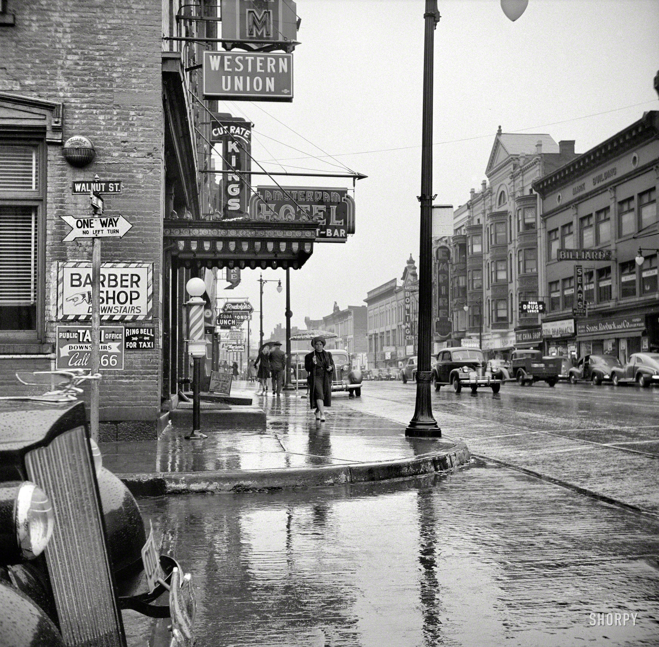 October 1941. "Amsterdam, New York." Walnut and East Main on a rainy day. Dare you to "Ring Bell for Taxi." Photo by John Collier. View full size.