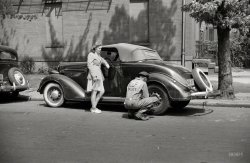 Spring 1942. "Girl having her tire changed in Southeast Washington." Photograph by Marjory Collins, Farm Security Administration. View full size.